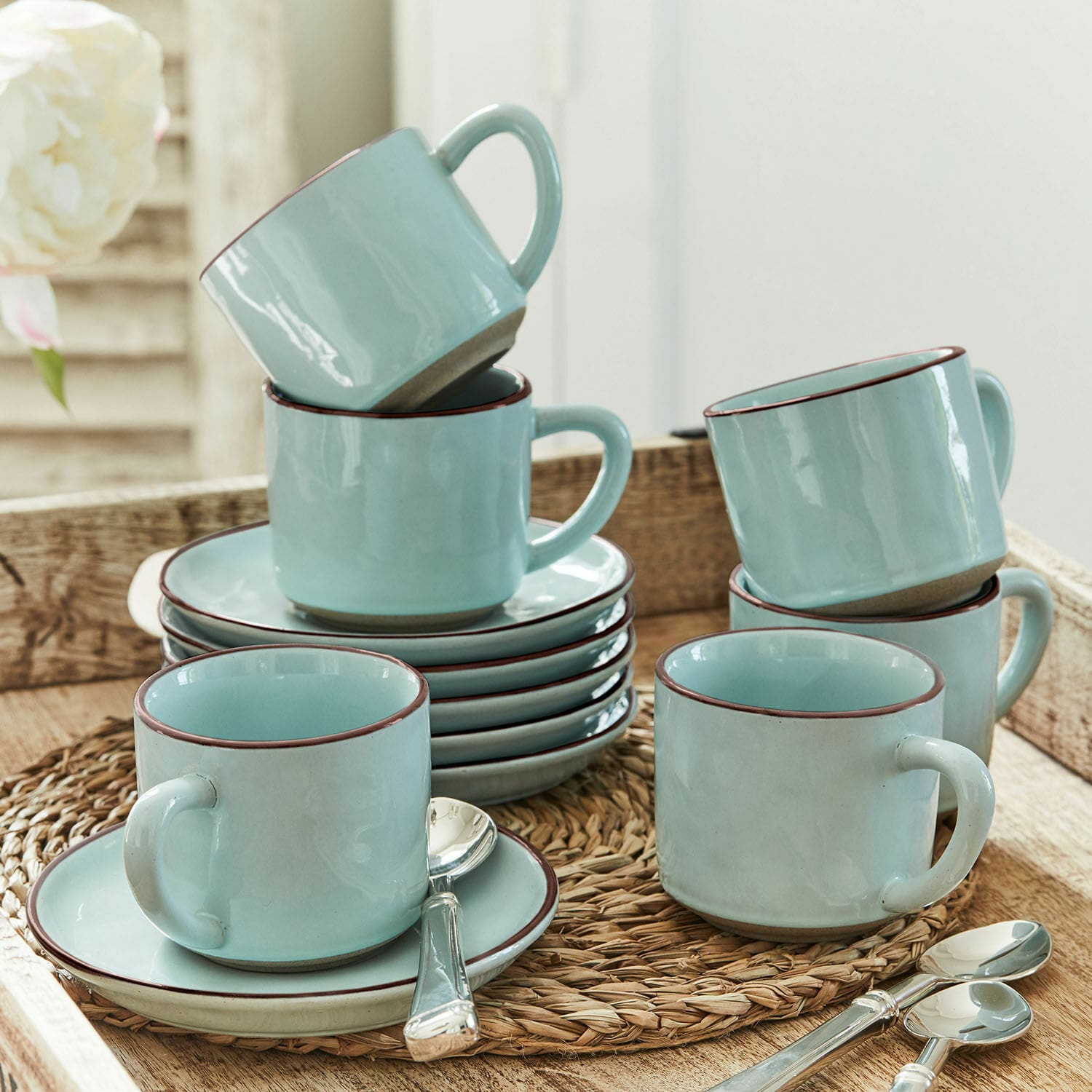 Lot de 6 tasses et soucoupes Biarré Ensemble de tasses en céramique bleu clair avec soucoupes et cuillères sur un dessous tressé
