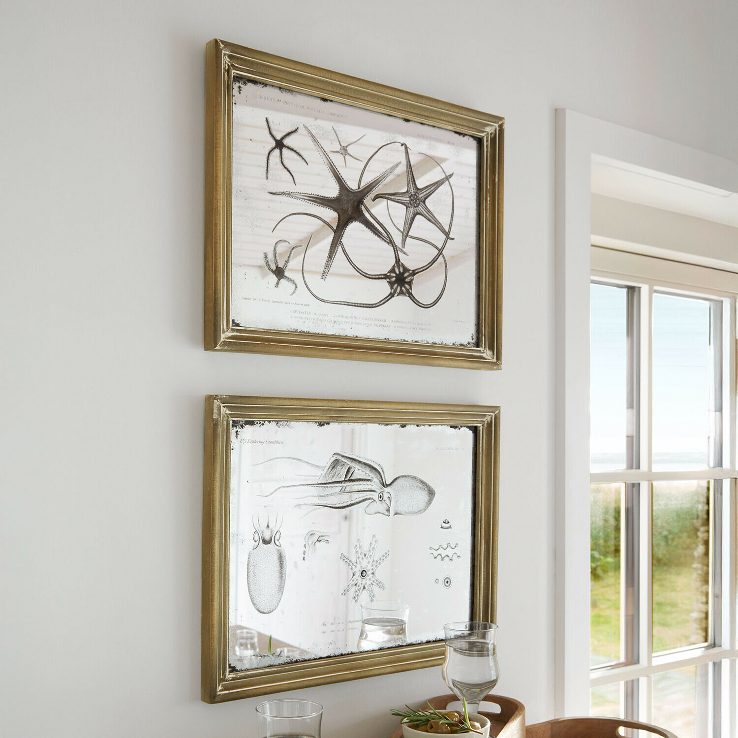 Lot de 2 miroirs à motifs Marivelles Deux cadres dorés avec miroir et illustrations marines, décoration murale dans une pièce lumineuse