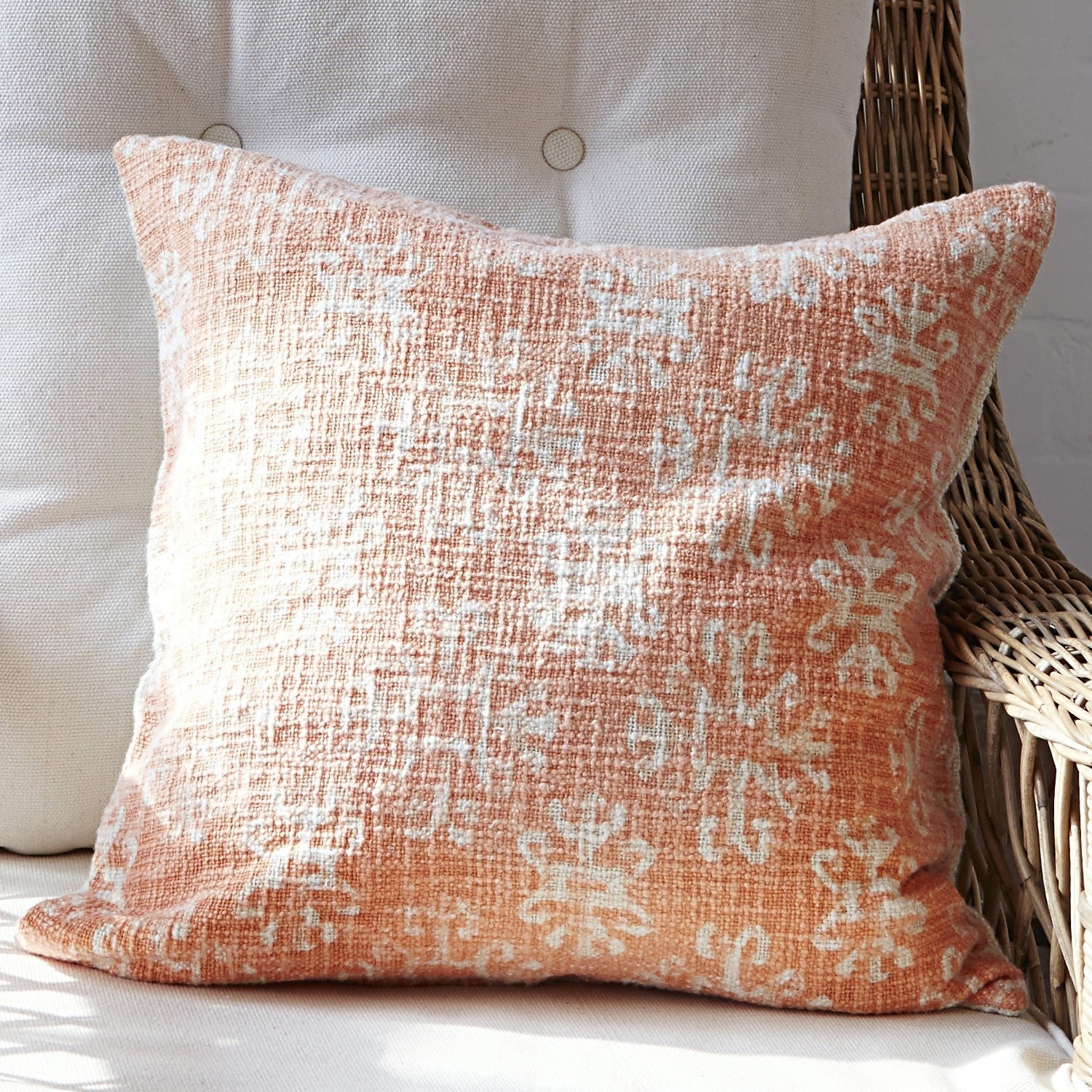 Coussin Kelli Coussin décoratif orange avec motif blanc en tissu texturé, idéal pour salon confortable