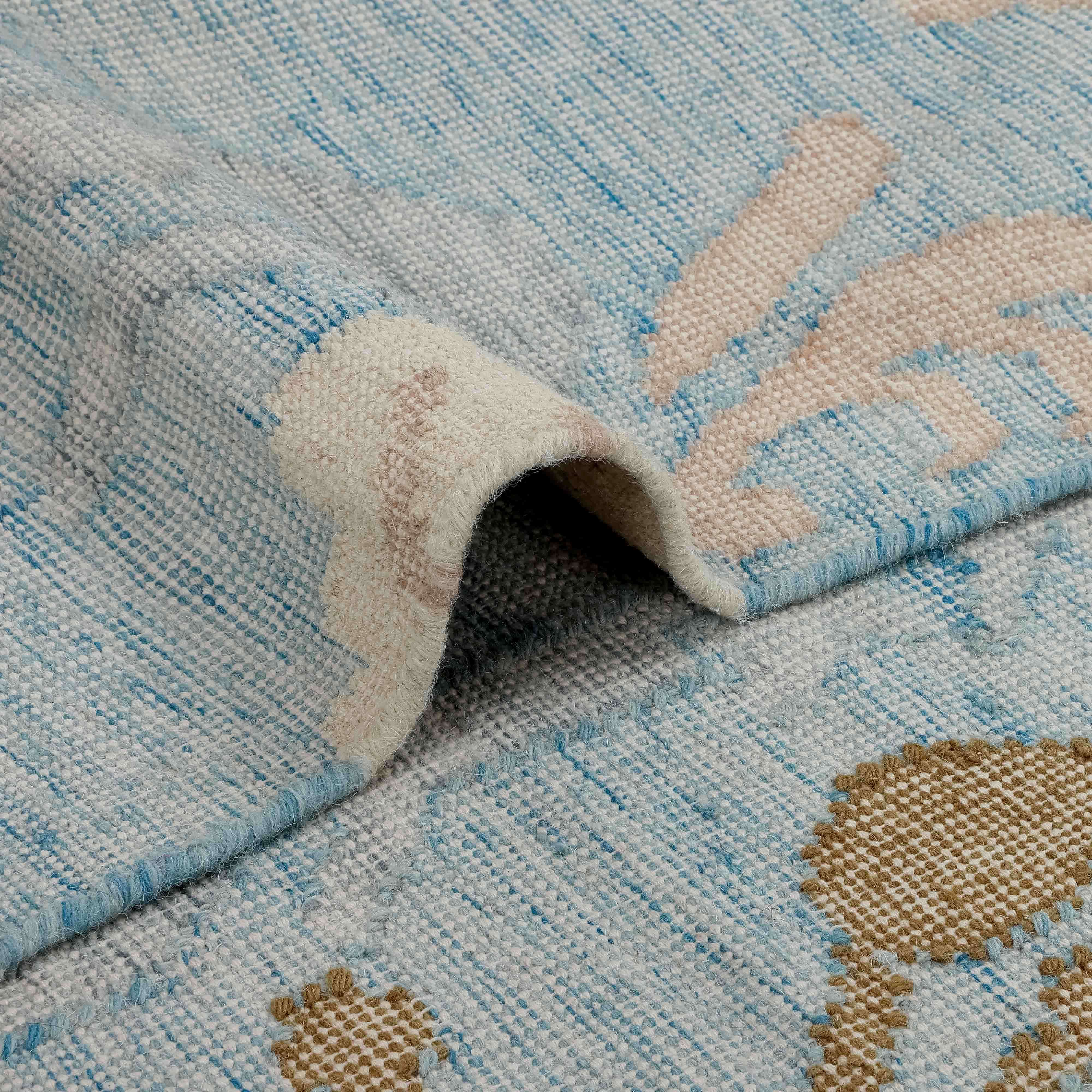 Tapis en tissu doux bleu clair et beige avec motif subtil, décoration intérieure élégante