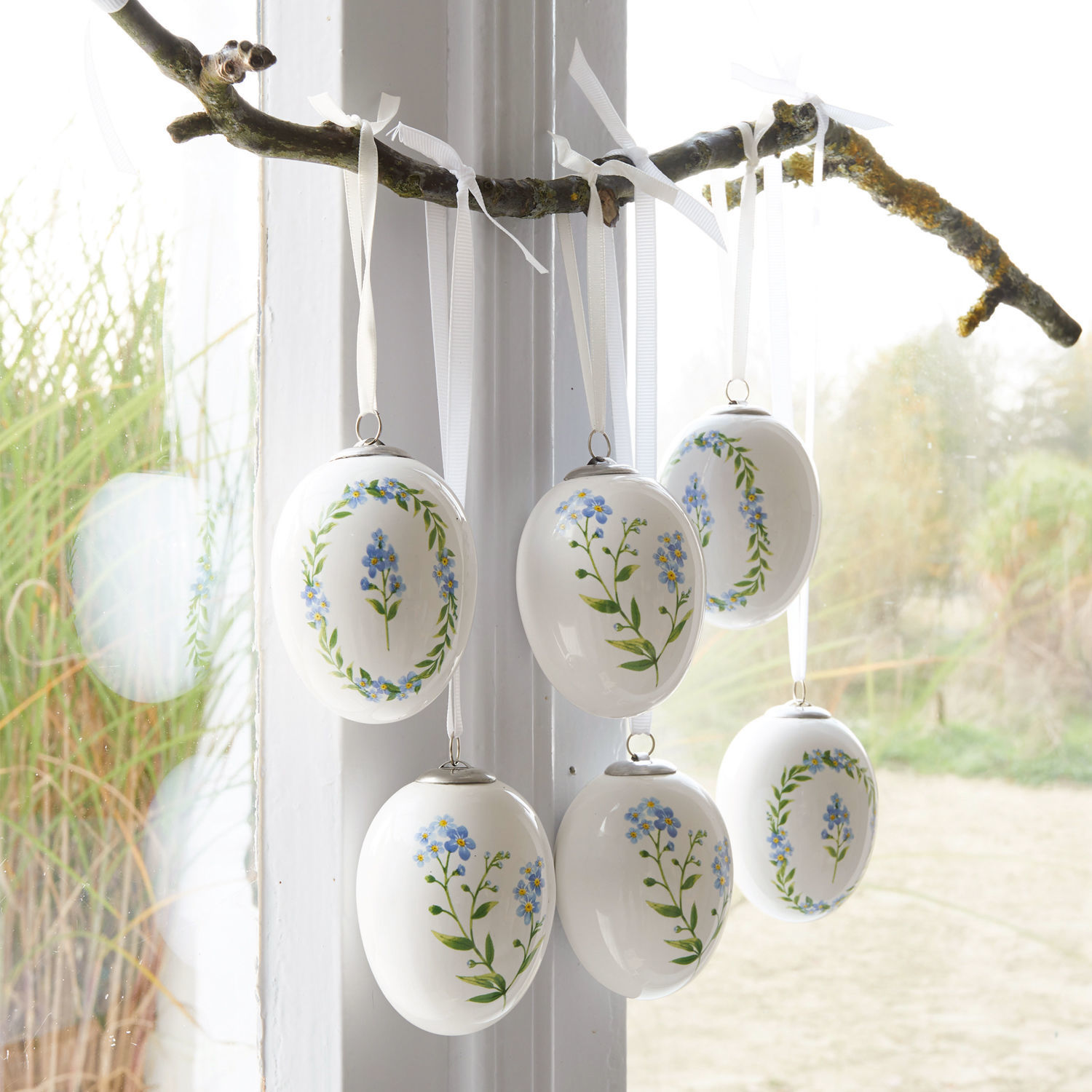 Lot de 6 œufs de Pâques Fierolla Œufs en céramique blanche avec fleurs bleues suspendus à une branche, décoration printanière