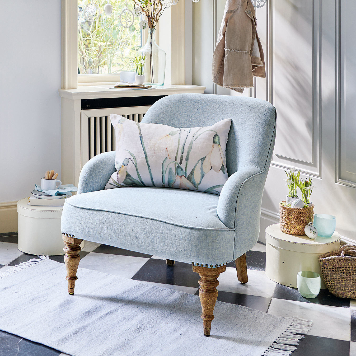 Fauteuil Ainsley Fauteuil bleu en tissu avec pieds en bois et coussin floral, parfait pour un salon élégant