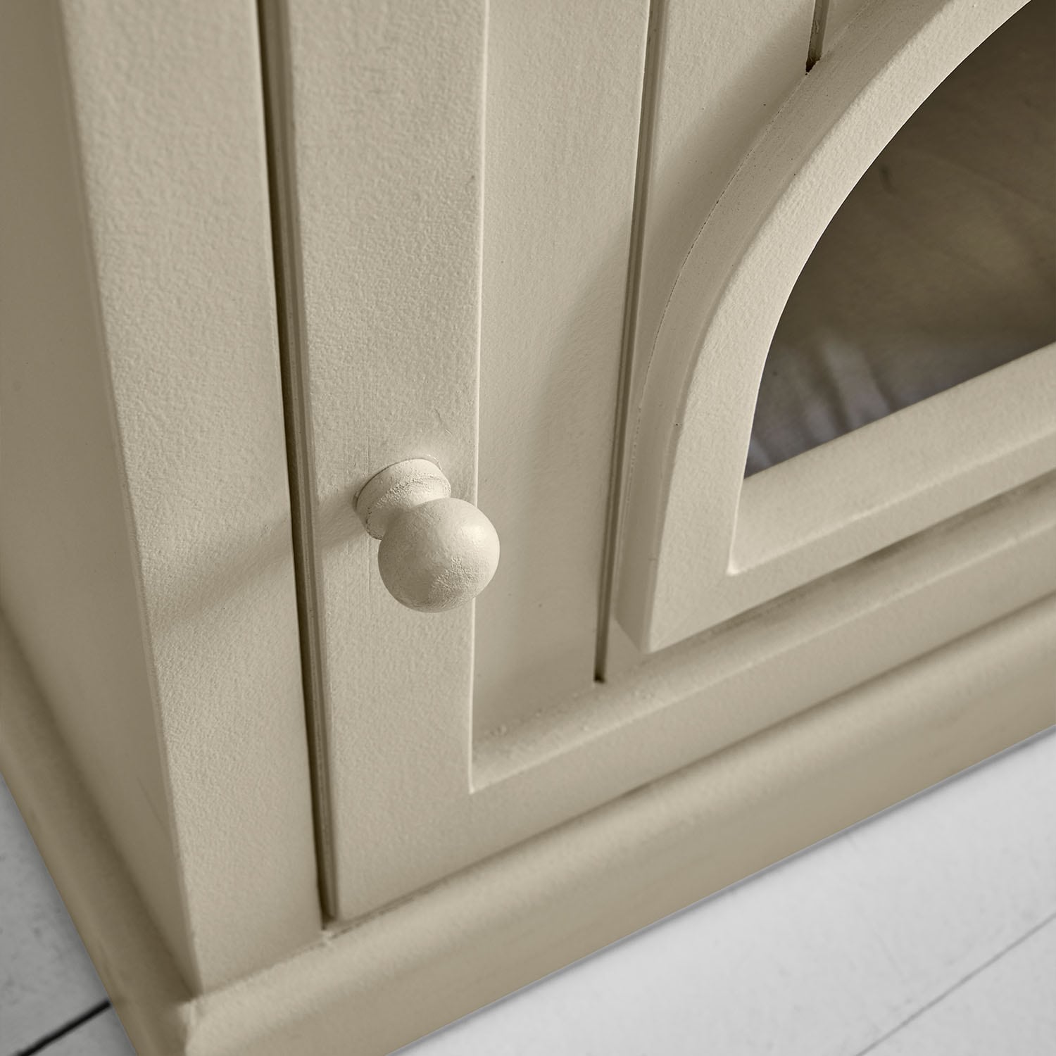 Armoire en bois beige avec poignée ronde et porte vitrée, meuble de rangement au style vintage