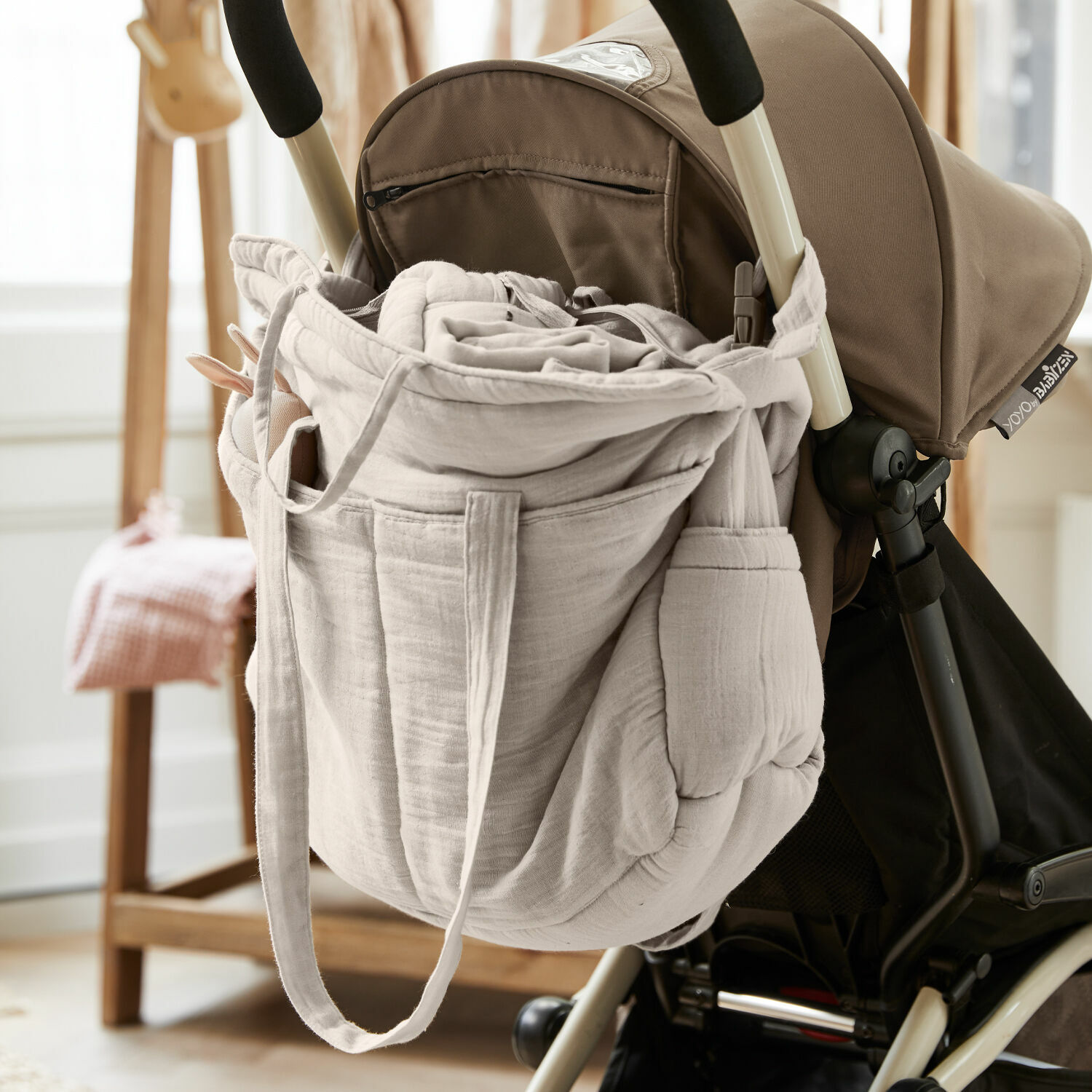 Sac à langer Mireval Sac beige en tissu doux accroché à la poignée d'une poussette, accessoire pratique pour les parents