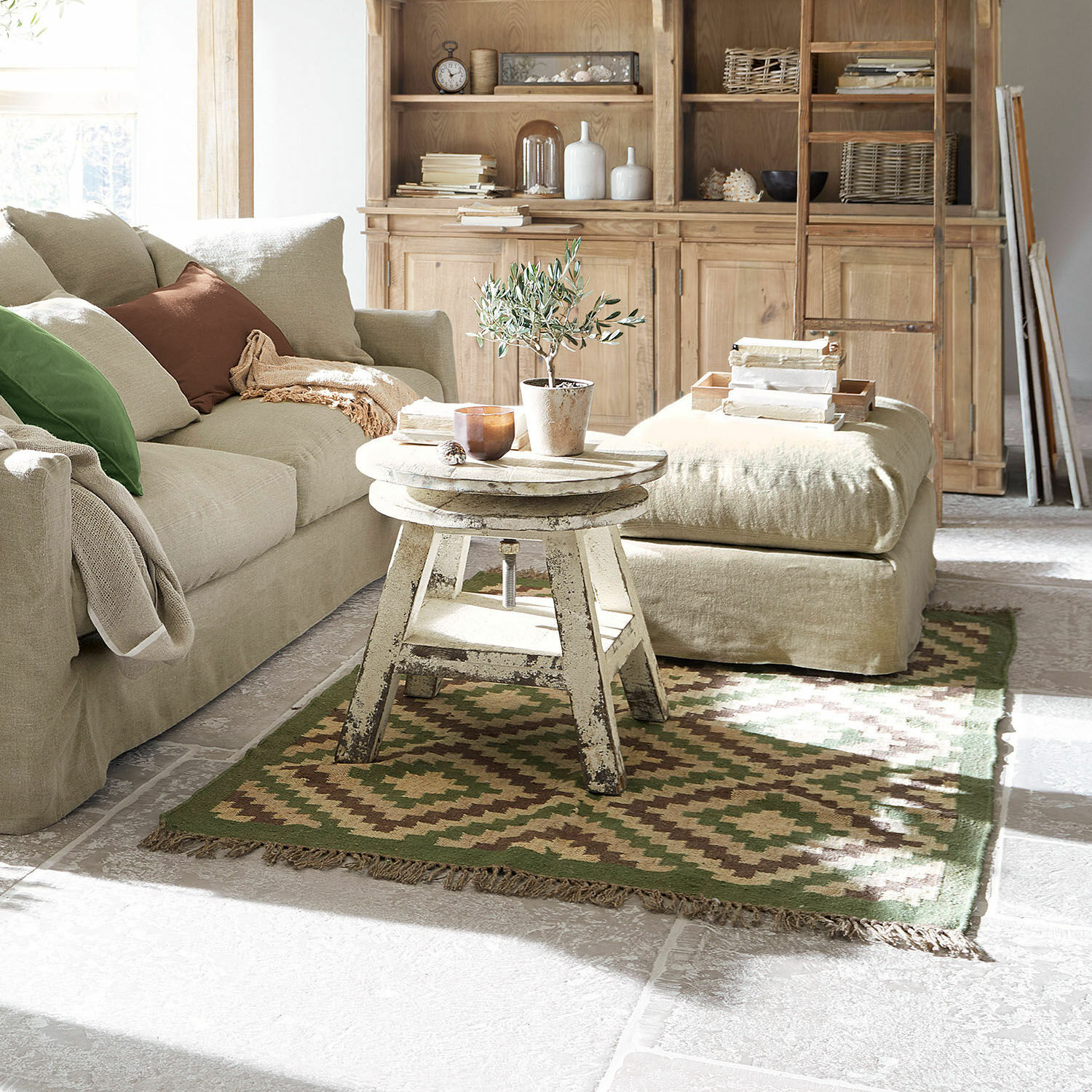 Tapis Dailies Salon chaleureux avec canapé beige, table en bois patiné et tapis vert et marron au style vintage