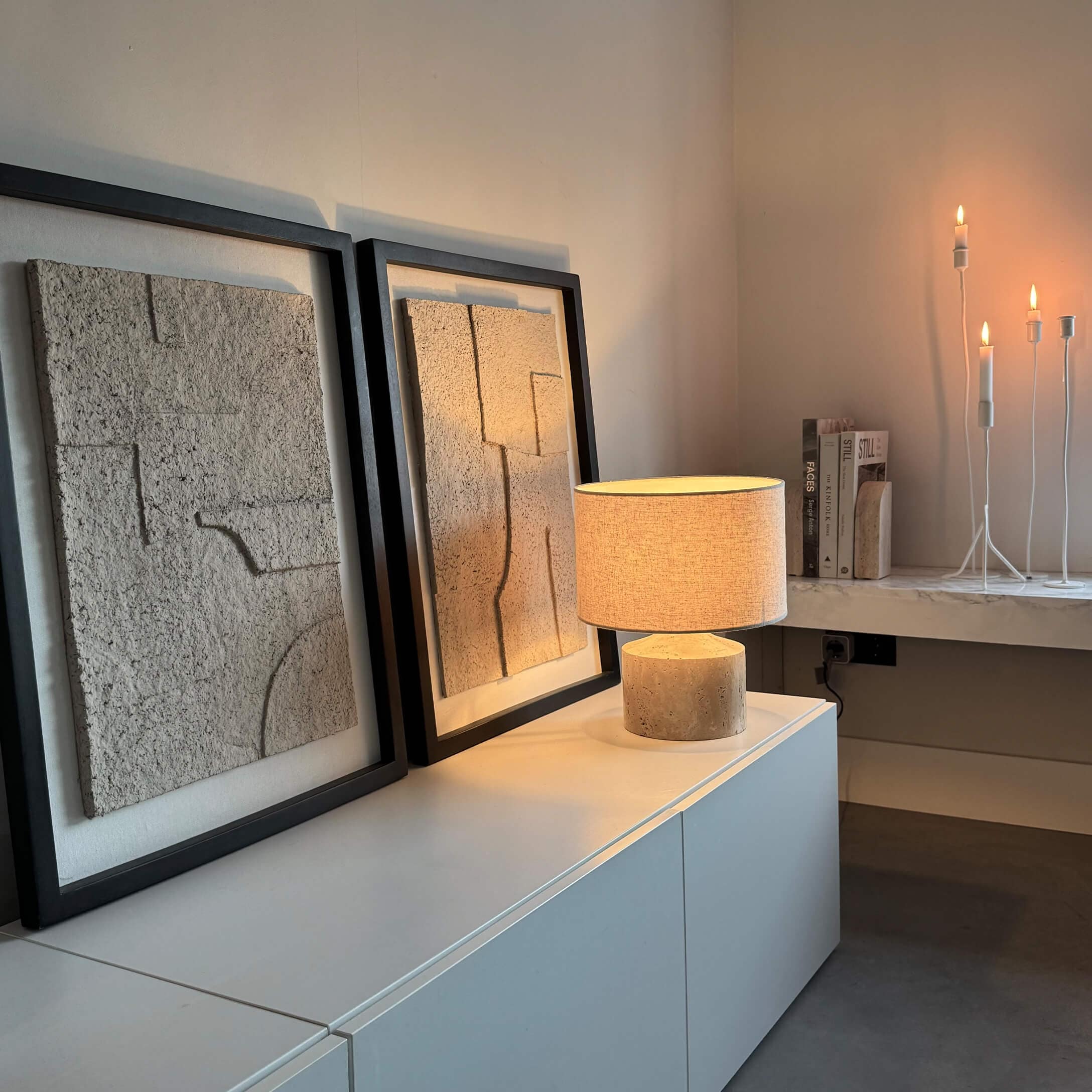 Lampe de table moderne avec abat-jour beige et base en pierre sur meuble blanc avec décor mural texturé