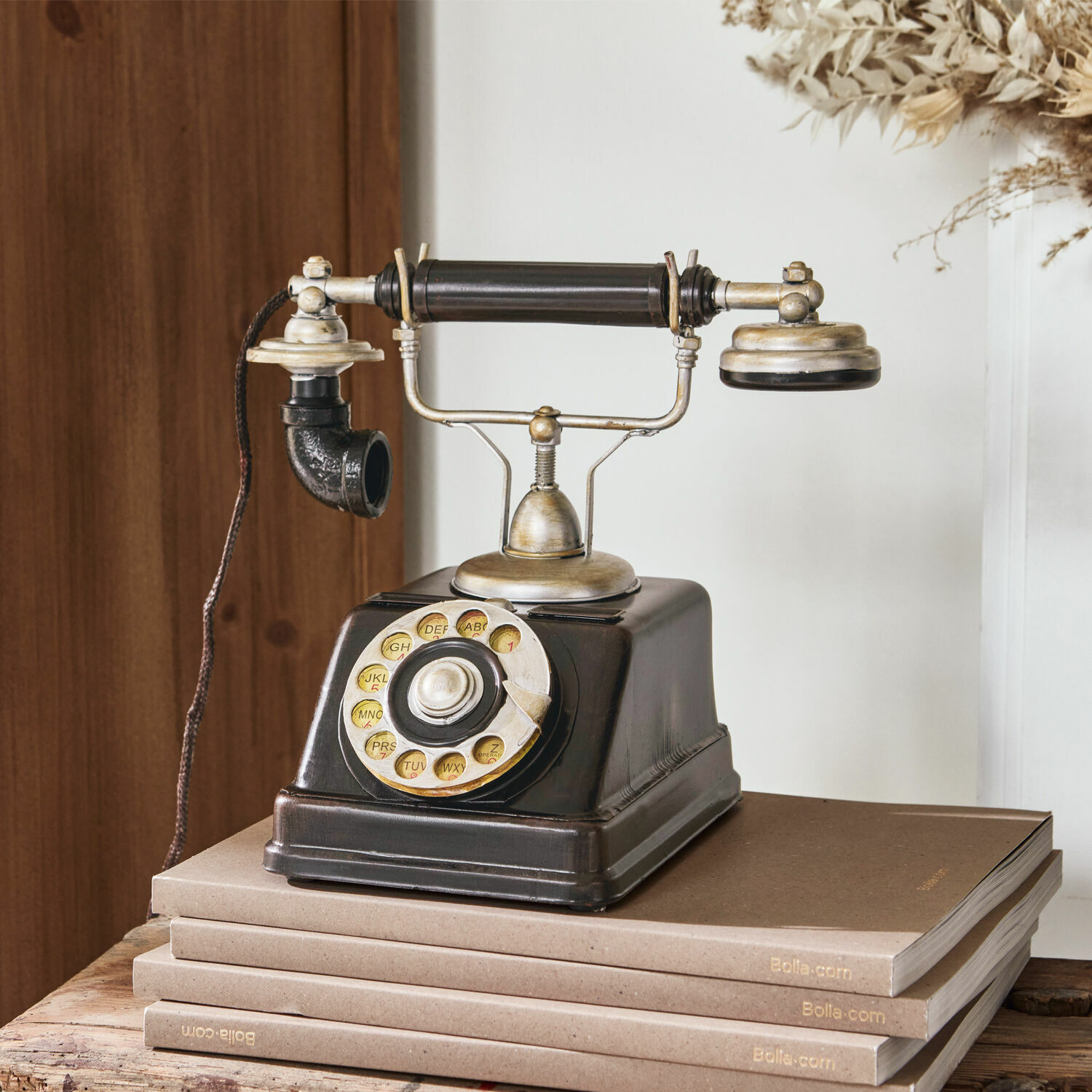 Téléphone décoratif Upavon Ancien téléphone noir à cadran rotatif avec éléments métalliques posé sur une pile de livres marron