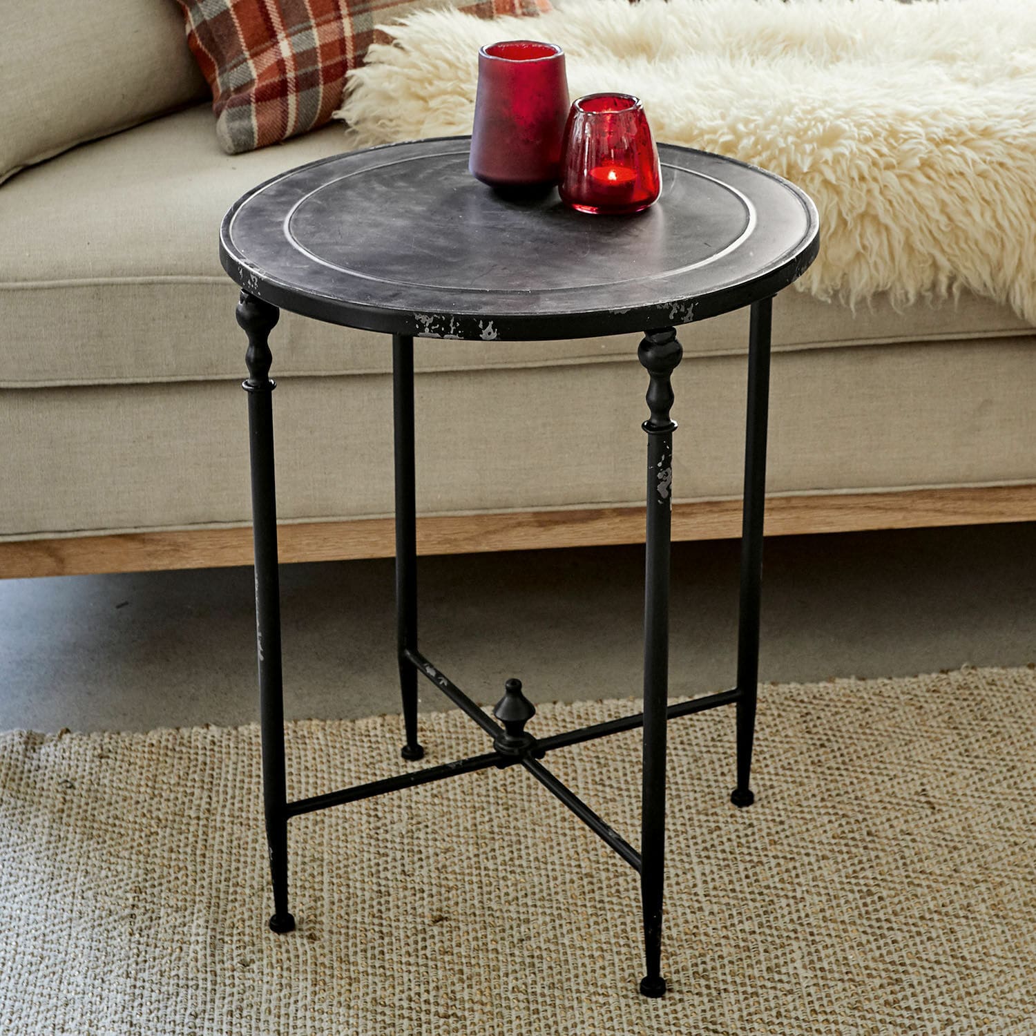 Table d’appoint Danbury Table d'appoint ronde en métal noir avec pieds décoratifs sur tapis beige dans un salon