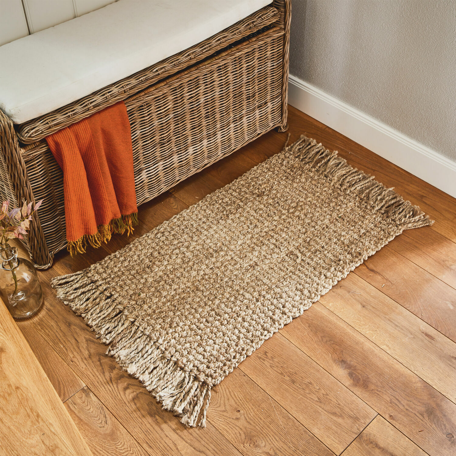 Paillasson Moody Tapis beige à franges en matériau naturel sur un sol en bois dans un intérieur chaleureux