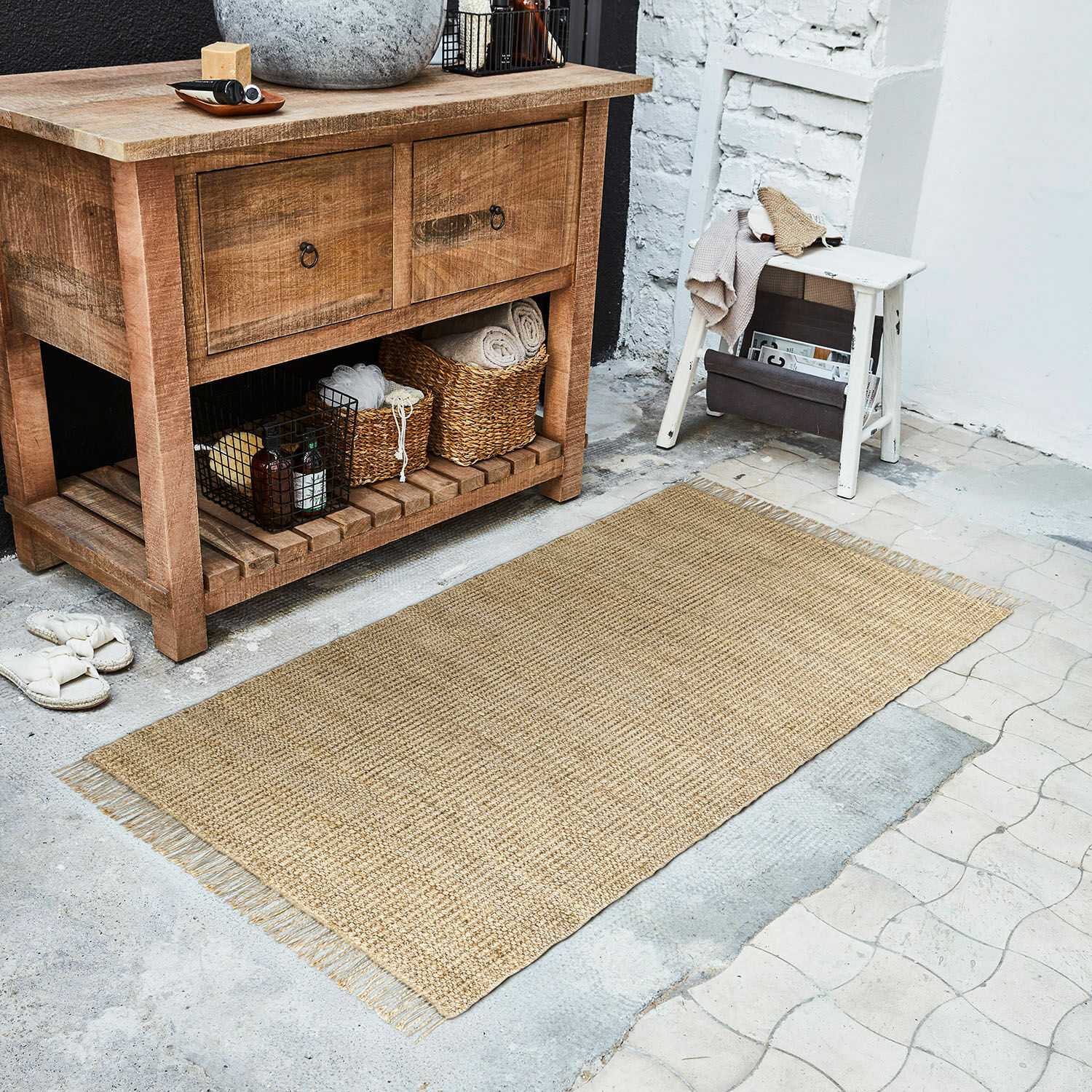 Tapis long Hermitage Tapis naturel en jute beige posé sur le sol près d'une commode en bois et d'un tabouret blanc
