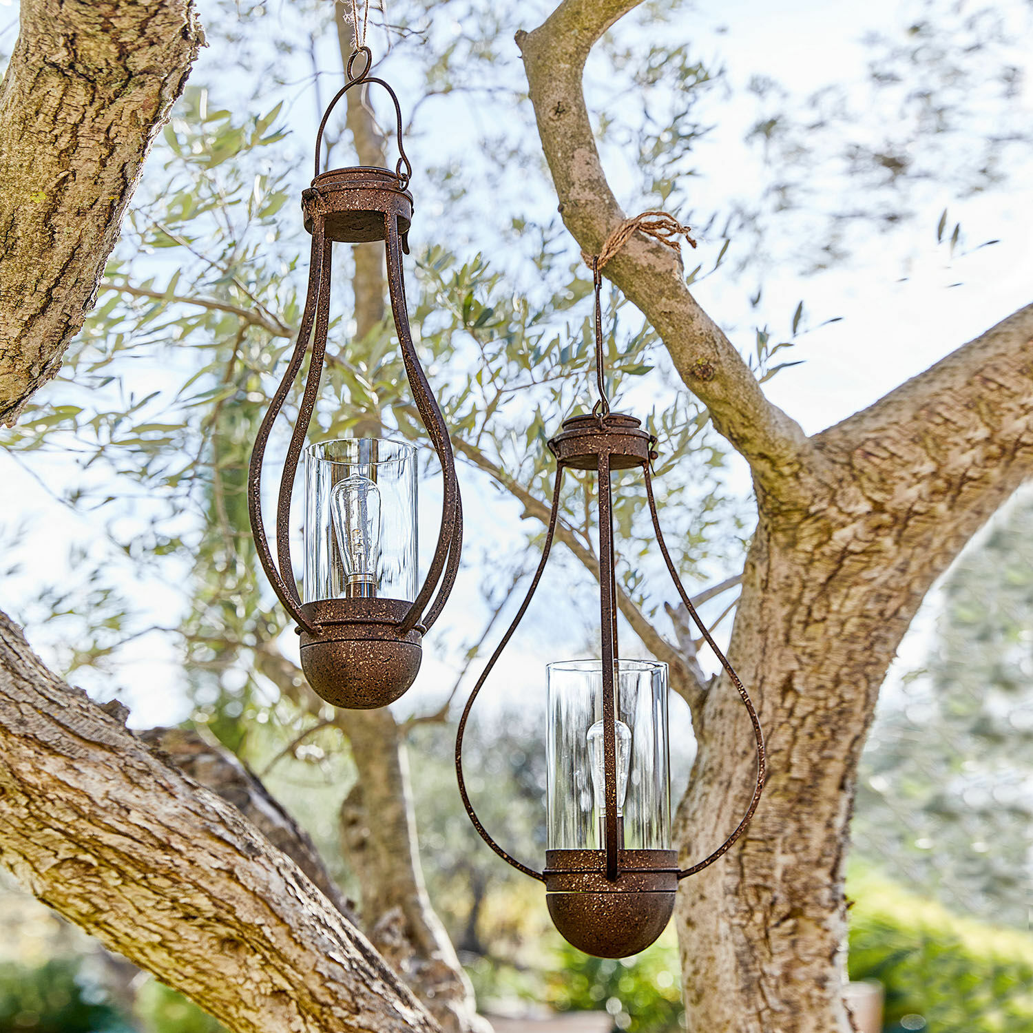 Lot de 2 lanternes solaires à suspendre Marsa Deux lanternes suspendues en métal rouillé avec verre transparent dans un jardin extérieur