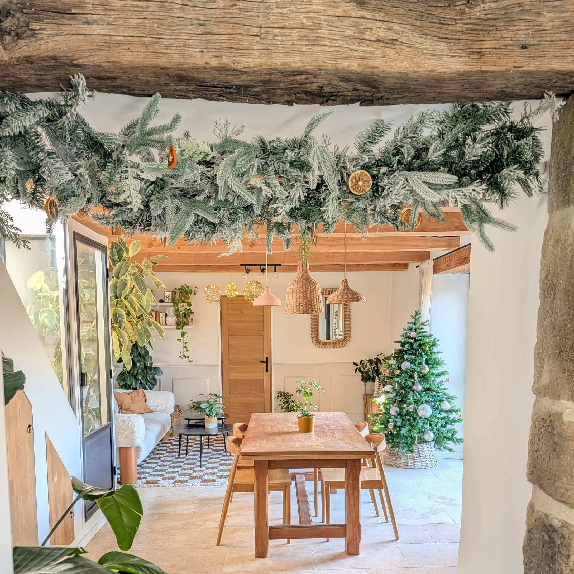 Intérieur chaleureux avec table en bois, sapin vert et guirlande de Noël aux tranches d'orange séchées