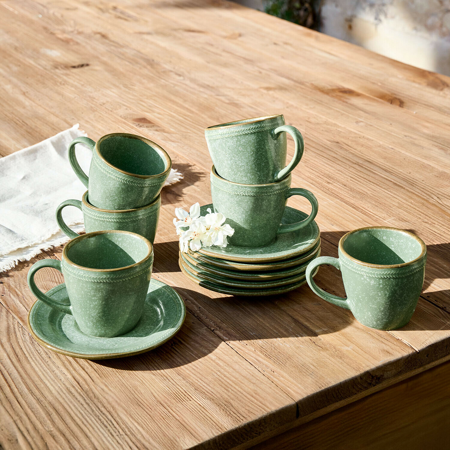 Lot de 6 tasses et soucoupes Norrvik Ensemble de tasses et soucoupes en céramique verte sur table en bois avec fleur décorative