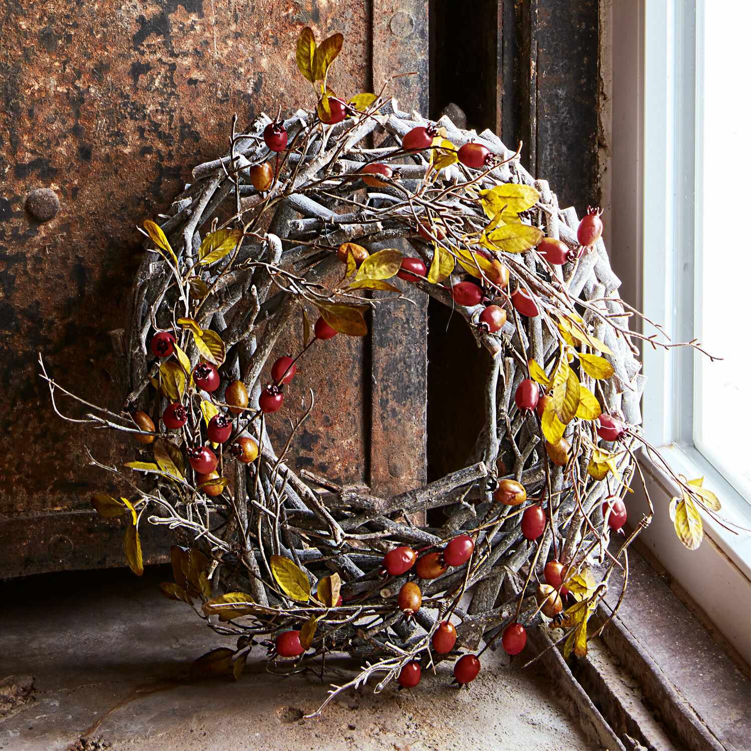 Couronne Mauriac Couronne décorative en branches avec baies rouges sur fond rustique près d'une fenêtre