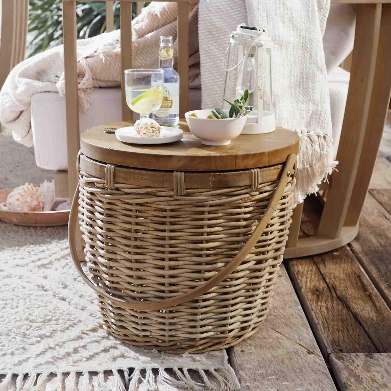 Table ronde en osier et bois naturel avec lanterne et snacks sur terrasse en bois rustique