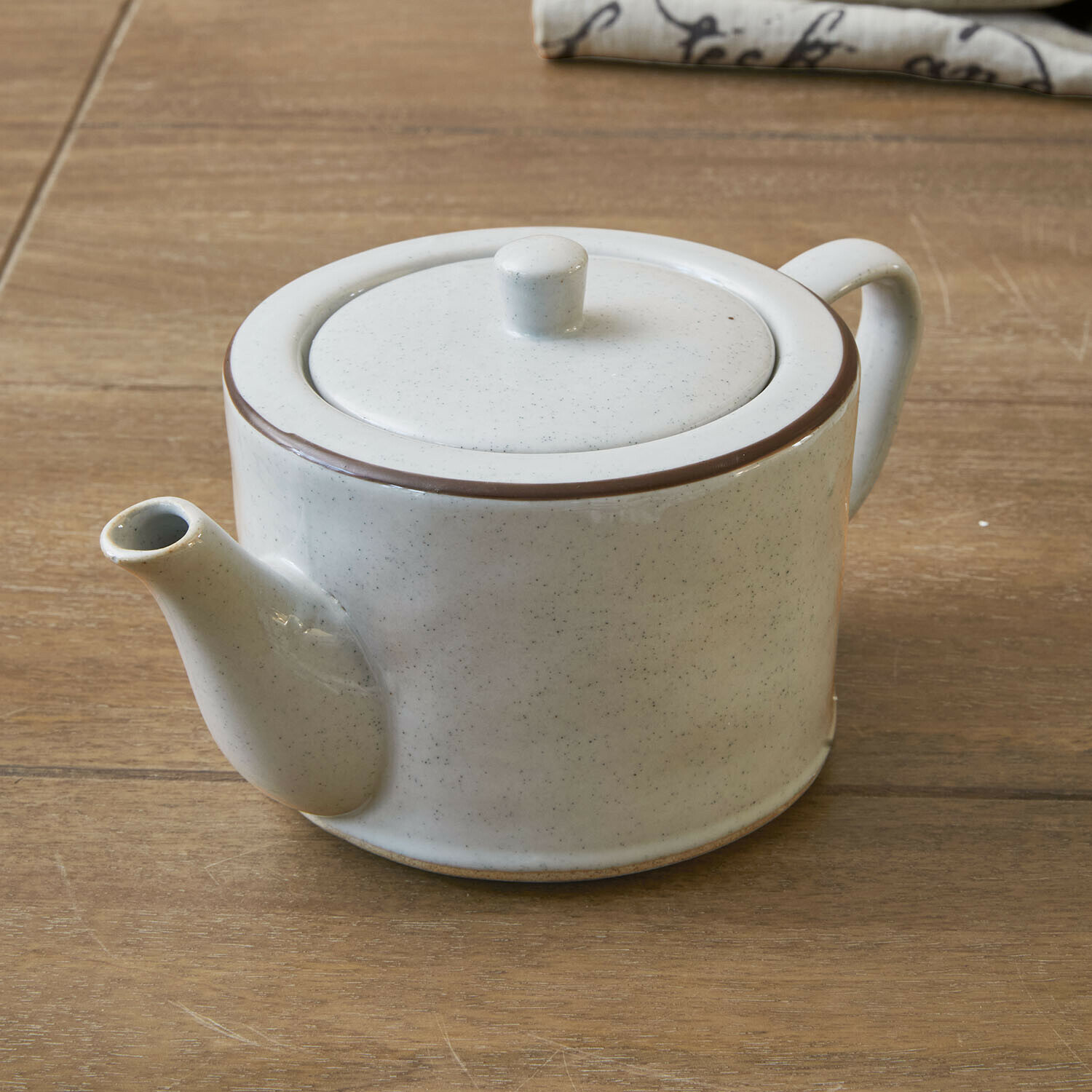 Théière Biarré Théière en céramique blanche avec bordure marron posée sur une table en bois pour infusion de thé