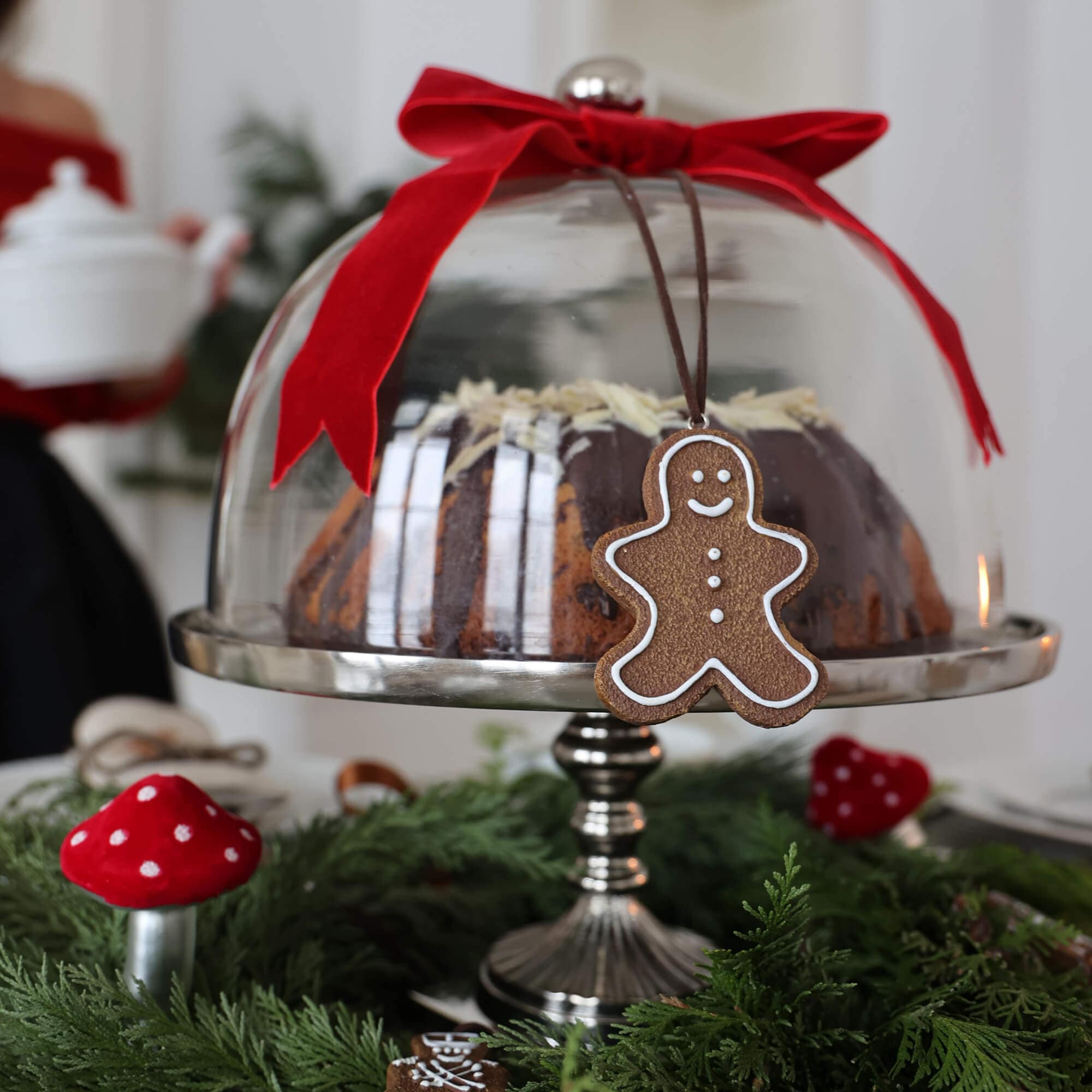 Cloche en verre avec ruban rouge et pendentif bonhomme en pain d'épices sur table de Noël