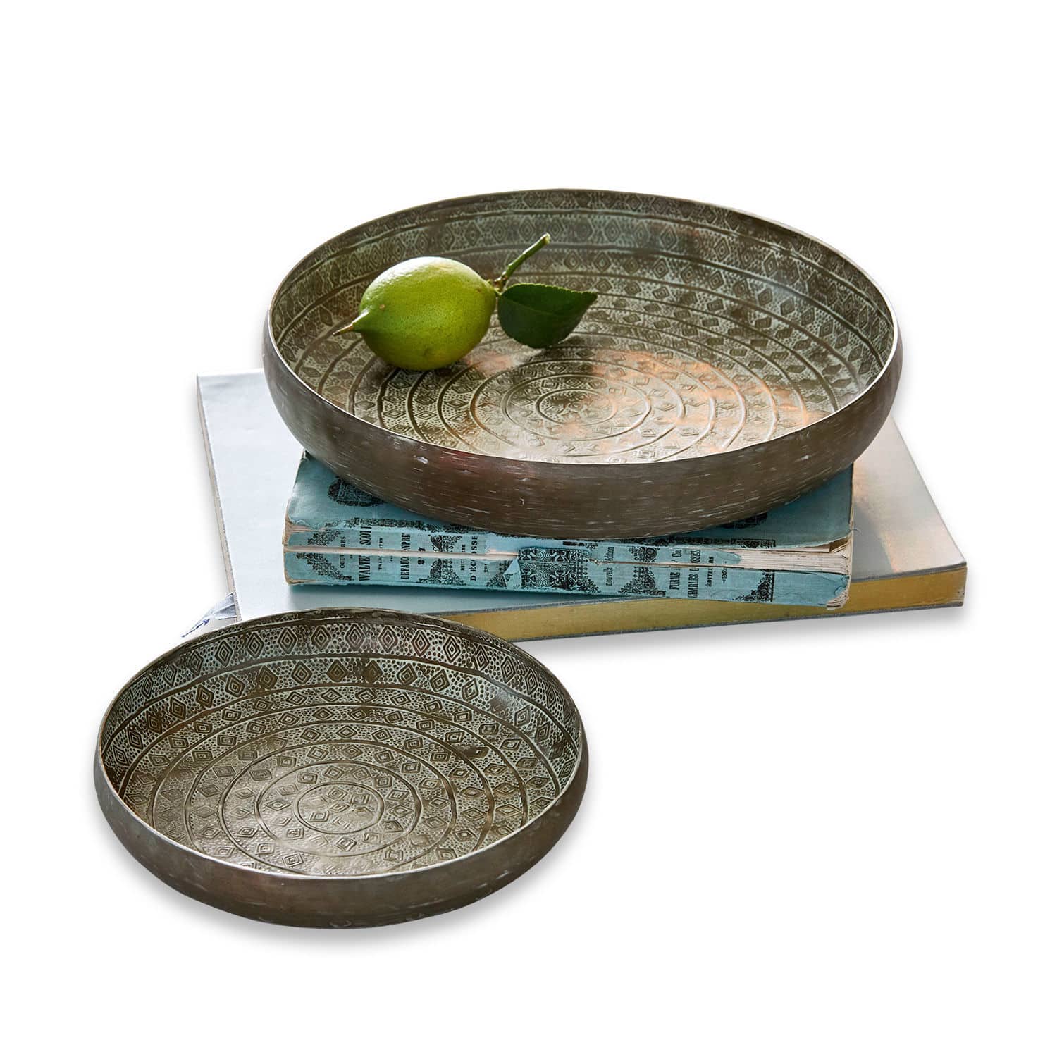 Lot de 2 plateaux Birse Ensemble de deux bols en métal argenté vieilli avec motifs décoratifs posés sur des livres