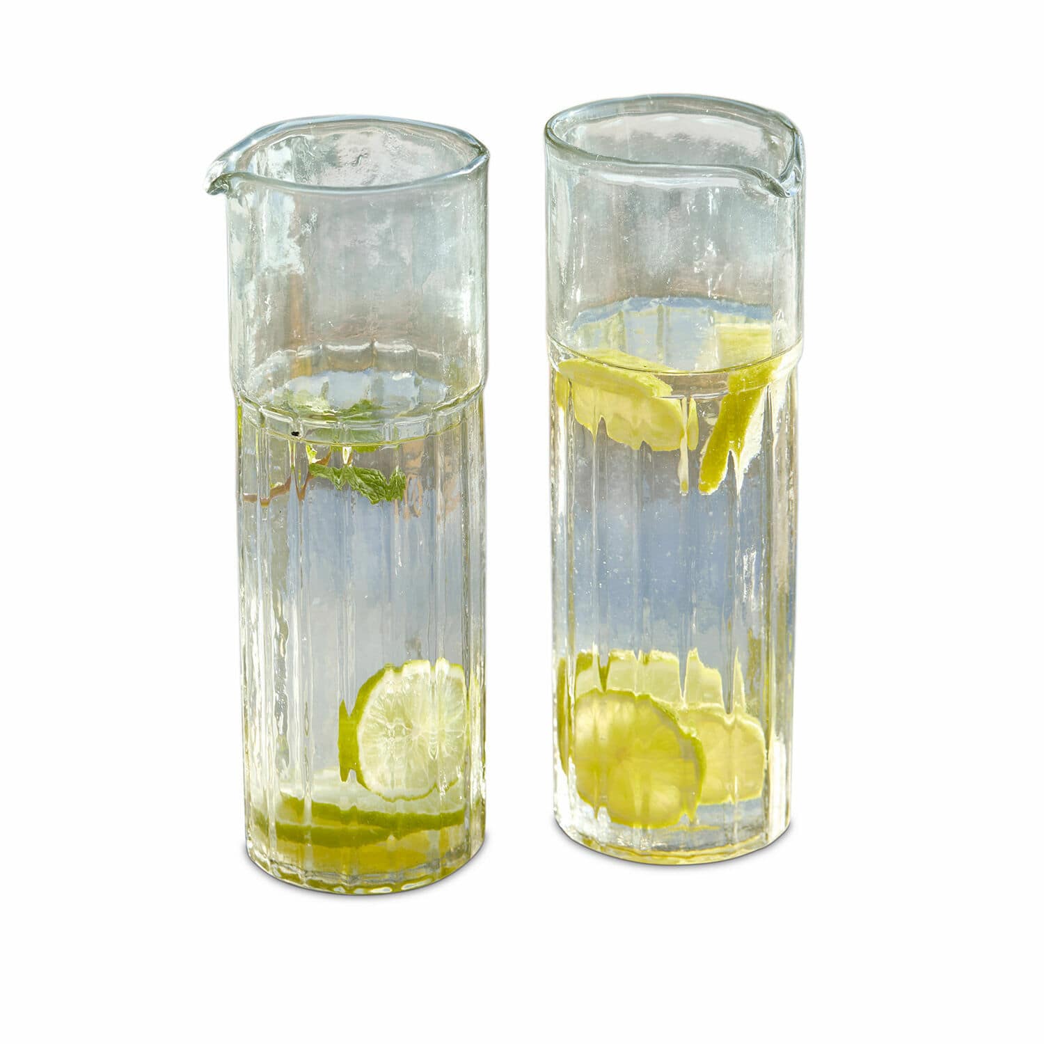 Deux carafes en verre transparent avec eau et tranches de citron, parfaites pour servir des boissons.