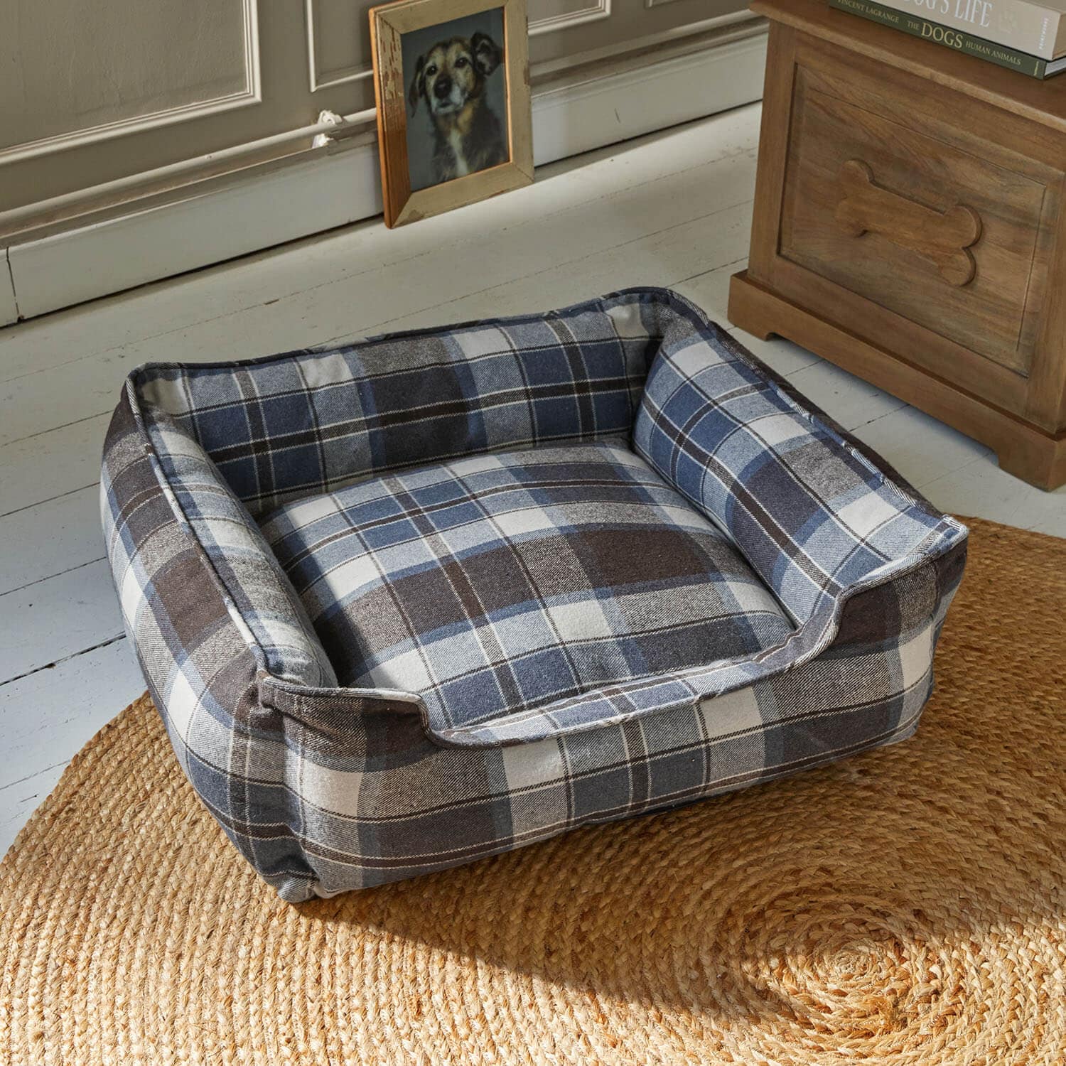 Panier pour chien confortable à carreaux bleu et marron sur tapis en jute dans un intérieur chaleureux
