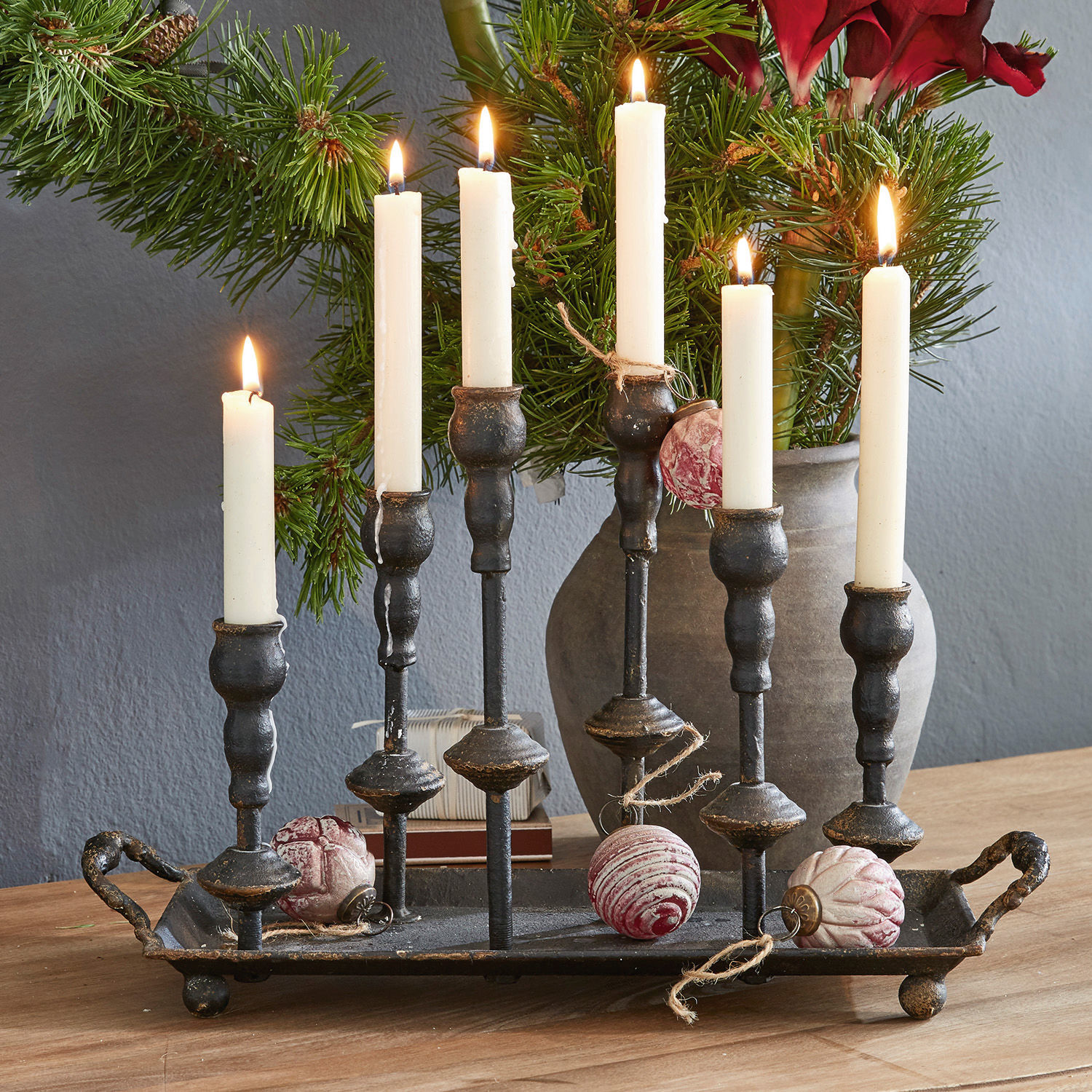 Bougeoirs Aisa Chandelier en métal noir avec six bougies blanches et décorations de Noël sur une table en bois