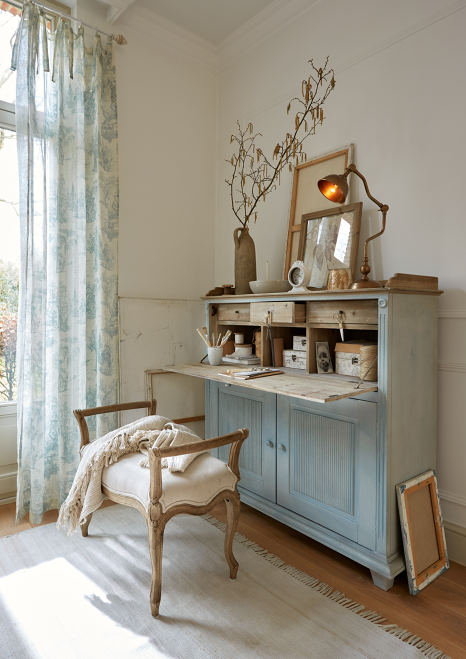 Buffet en bois bleu avec plateau rabattable et décorations dans une pièce lumineuse et chaleureuse