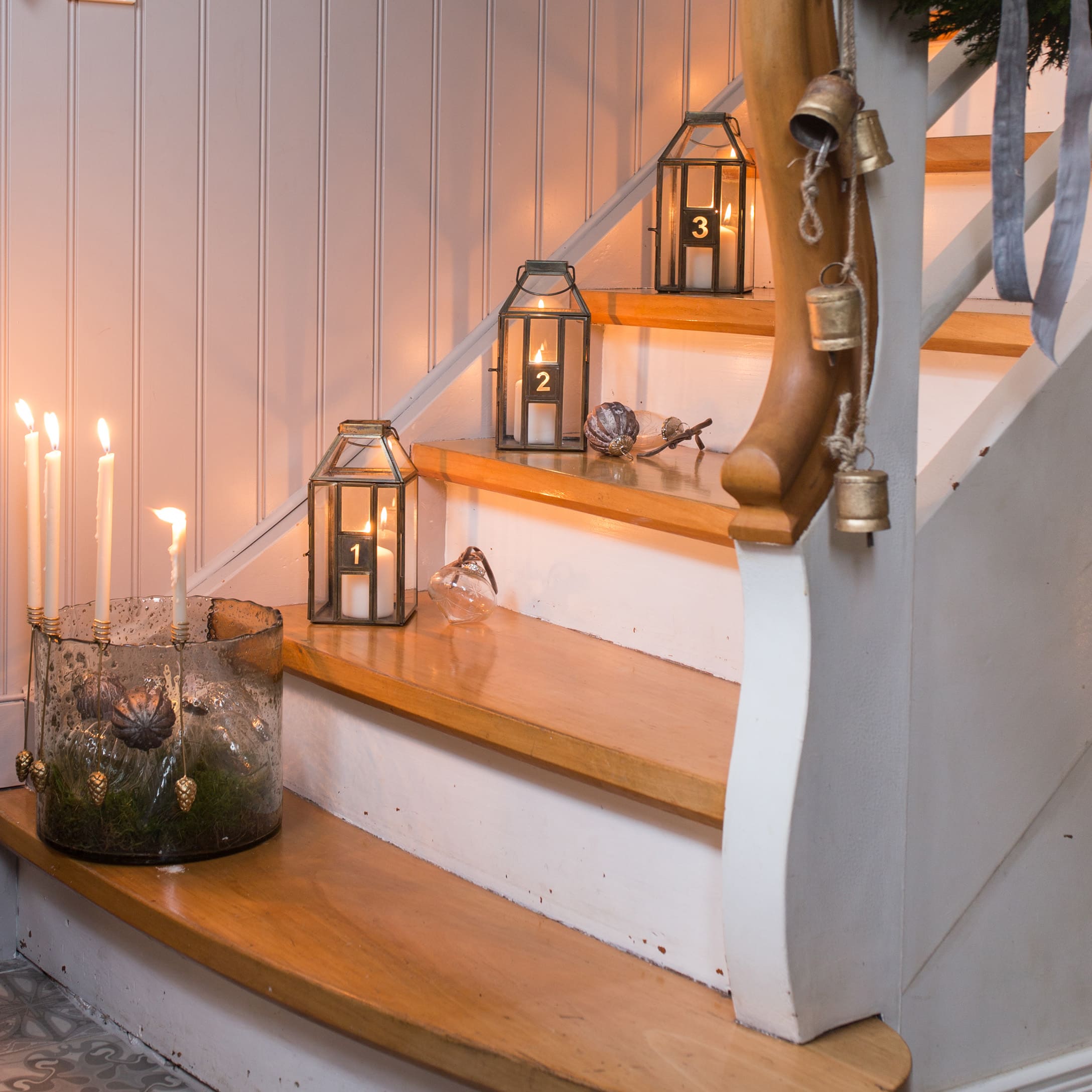 Escalier en bois décoré de lanternes numérotées et bougies pour une ambiance chaleureuse