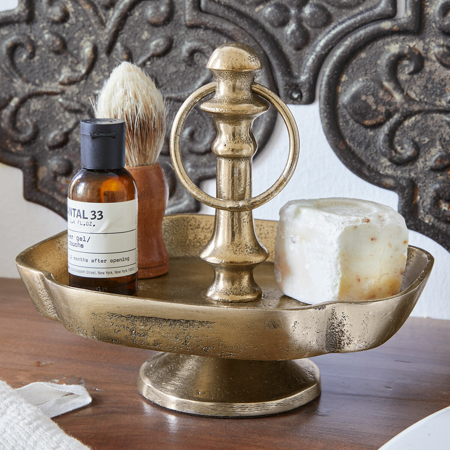 Présentoir à étage Frinesto Porte-savon en métal doré avec poignée, savon et accessoires de rasage sur table en bois
