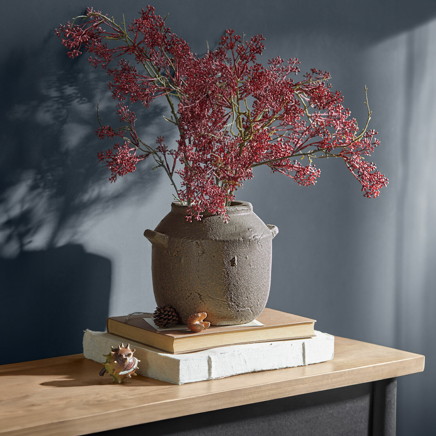 Vase Saintevoux Vase en céramique marron rustique avec branches rouges sur table en bois avec livres