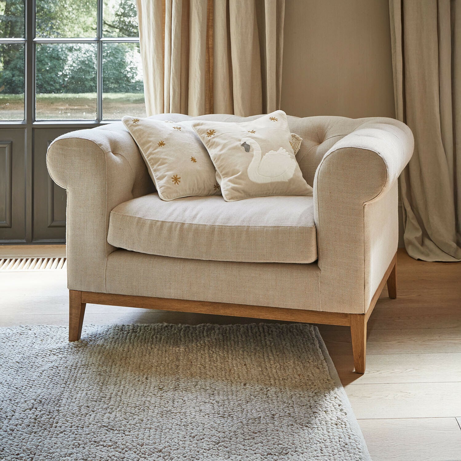 Fauteuil Fairbourne Canapé beige en tissu avec base en bois et deux coussins décoratifs brodés d'un cygne