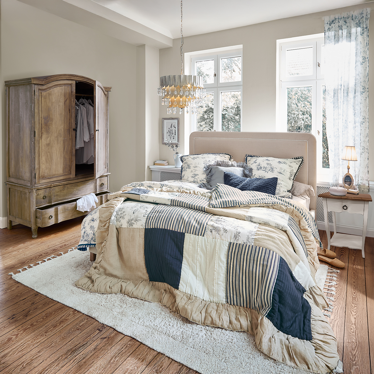 Chambre chaleureuse avec couvre-lit patchwork beige et bleu marine, armoire en bois et tapis moelleux