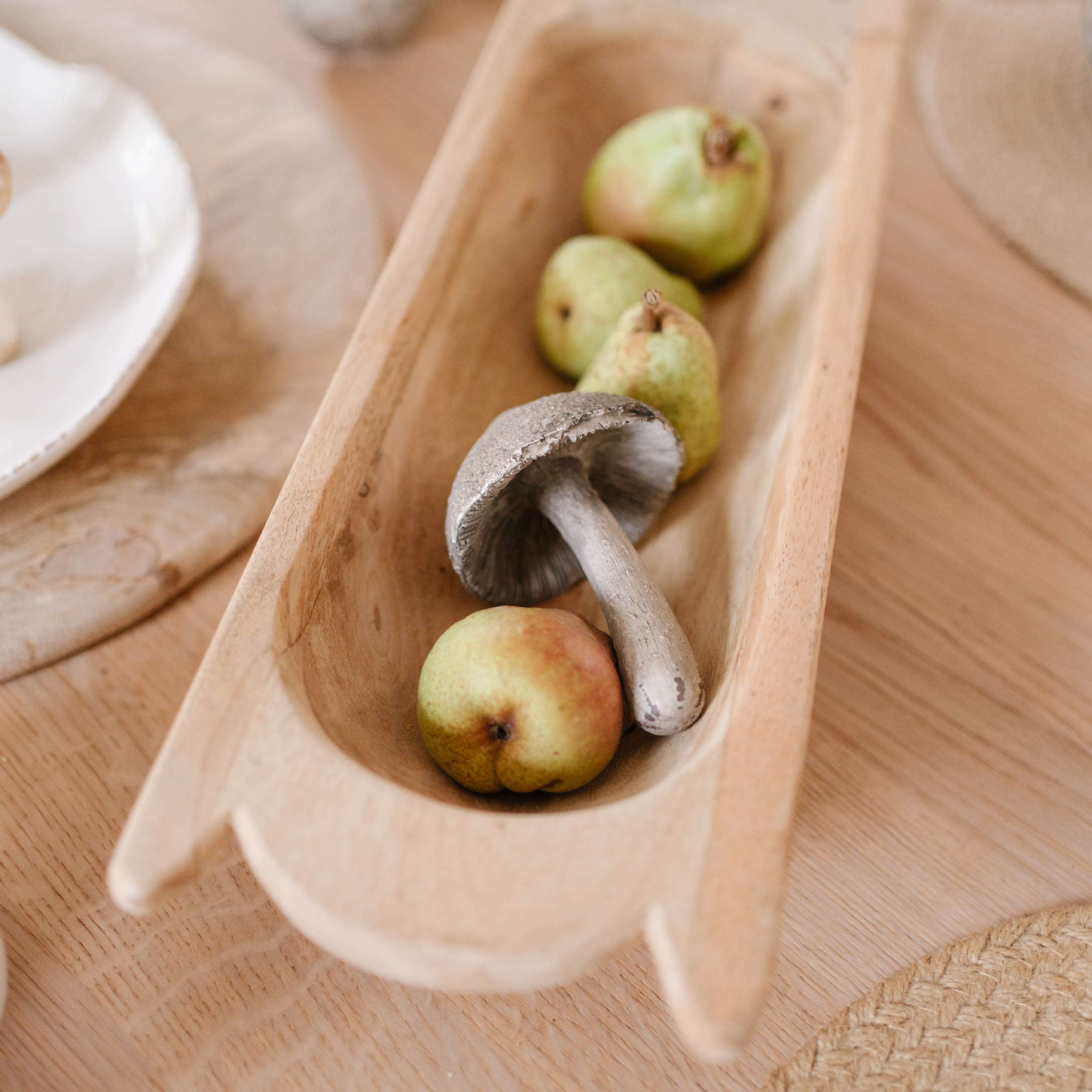 Plat en bois avec champignon décoratif et poires vertes pour une table d'automne