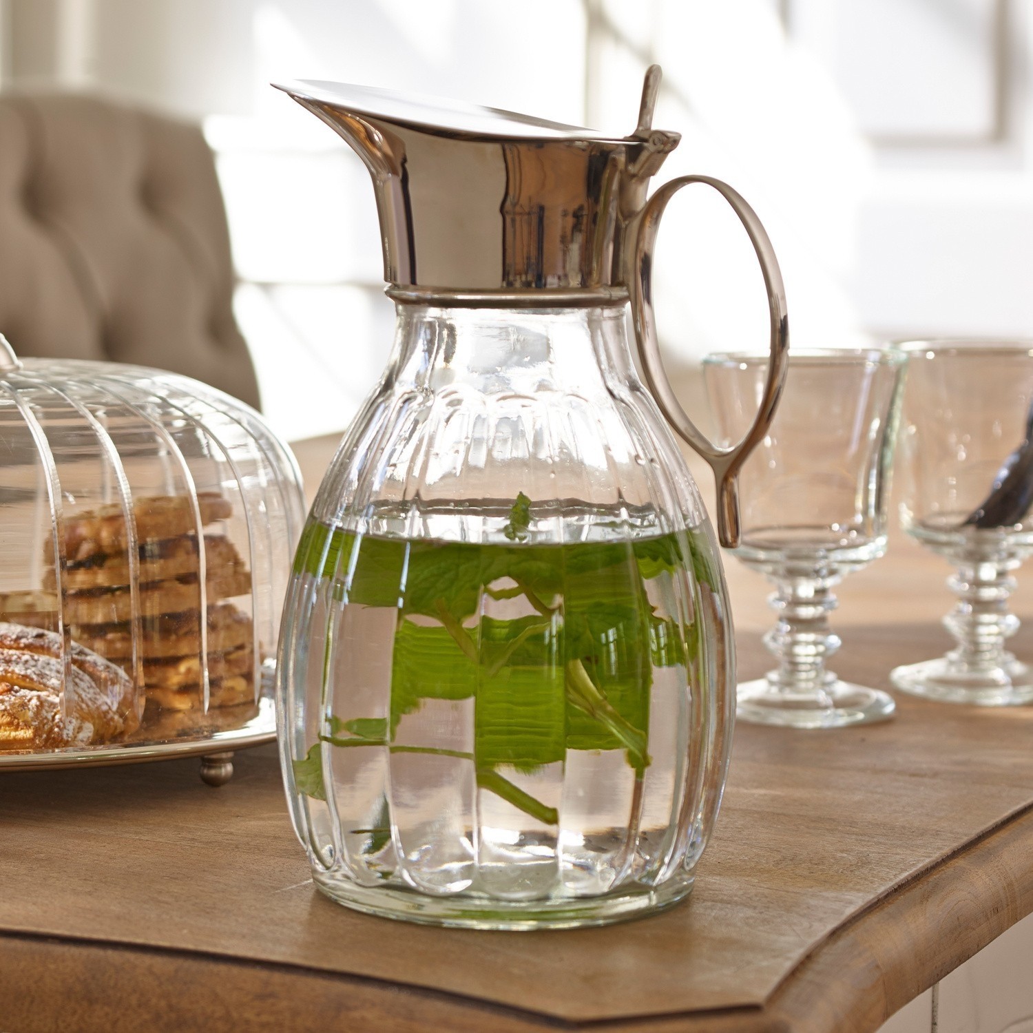 Pichet Agudelle Carafe en verre avec couvercle et poignée en métal, eau infusée à la menthe sur table avec pâtisseries