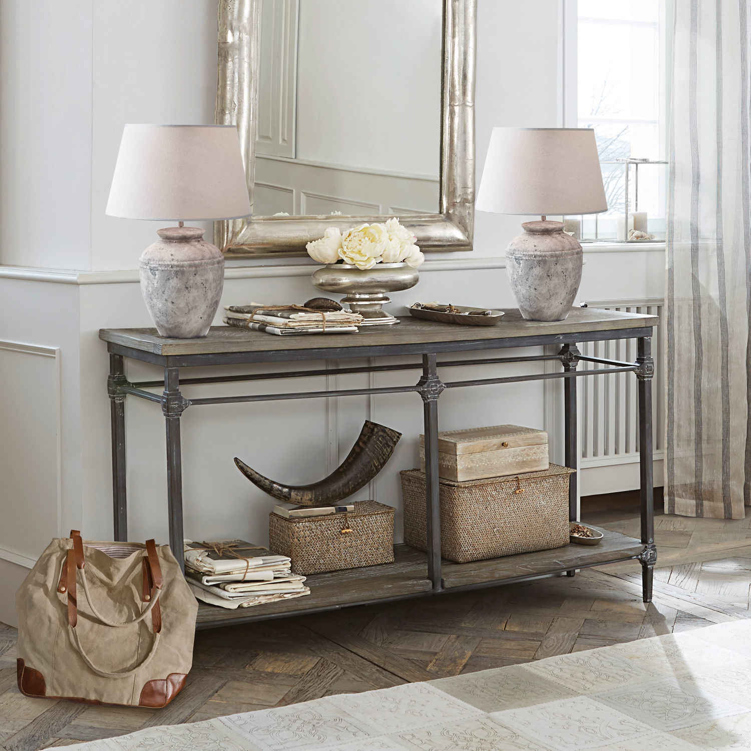Console Caspian Console vintage en bois et métal avec lampes et décorations beige dans un intérieur lumineux et élégant