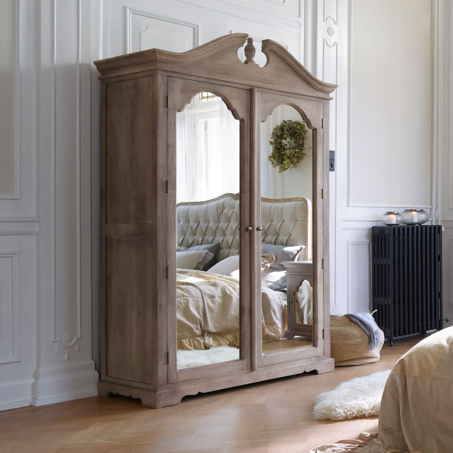 Armoire Somerset Armoire en bois avec portes miroir style vintage dans une chambre claire avec parquet en bois