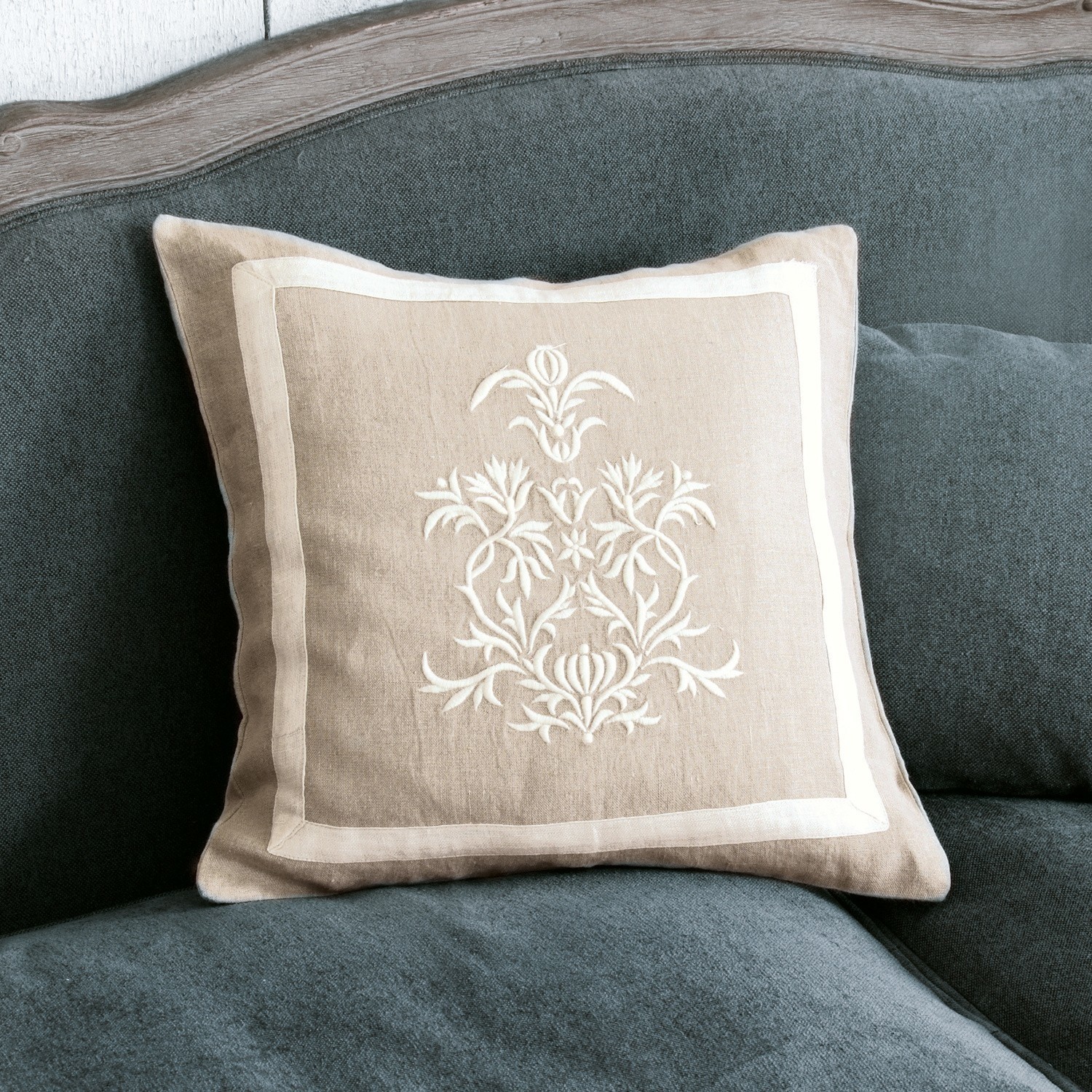 Housse de coussin Many Coussin beige en lin avec broderie blanche sur canapé gris, accessoire déco élégant pour salon