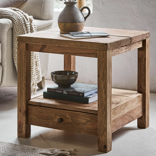 Table carrée en pin naturel avec tiroir et étagère pour livres dans un salon lumineux