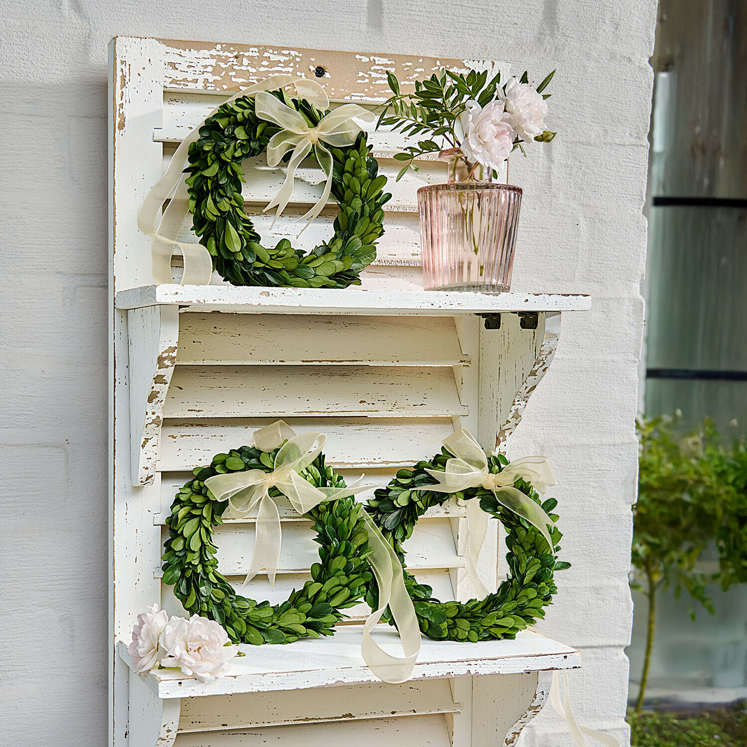 Lots de 3 couronnes Islene Couronnes décoratives vertes en feuilles avec rubans crème sur étagère en bois blanc style vintage