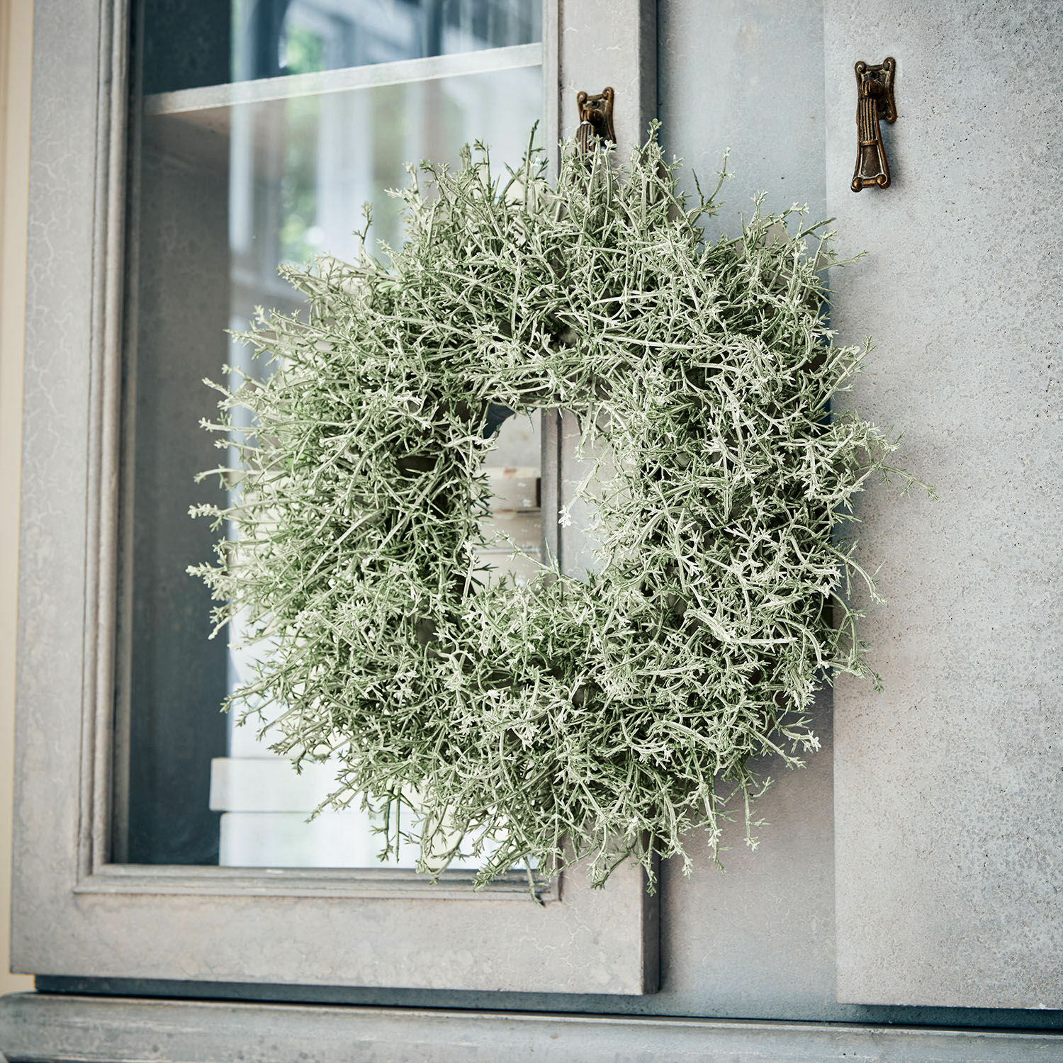Couronne Senailly Couronne décorative en branches vertes accrochée à une porte grise, décoration intérieure et extérieure