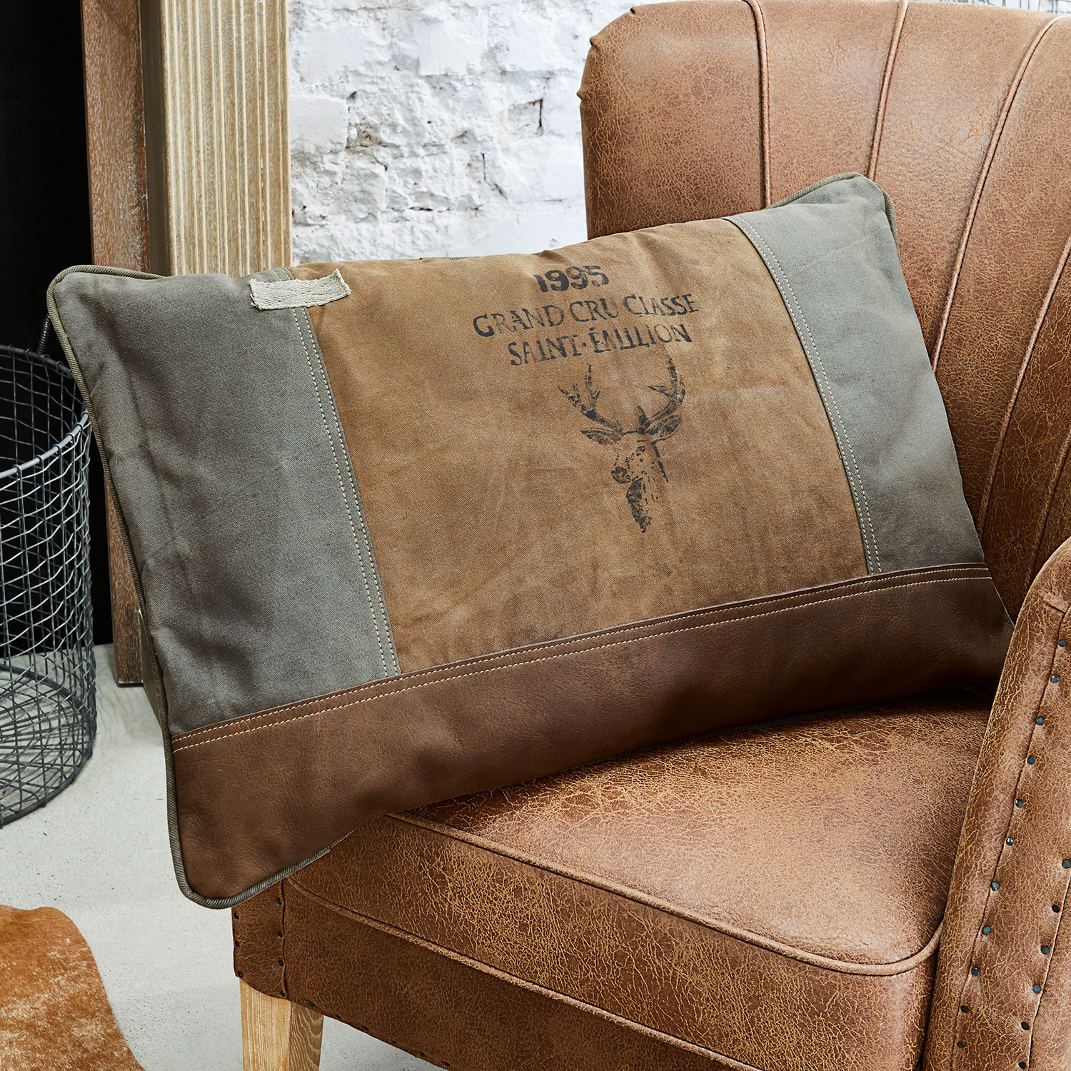 Coussin Chiron Coussin décoratif marron et gris avec motif cerf sur fauteuil en cuir, style vintage