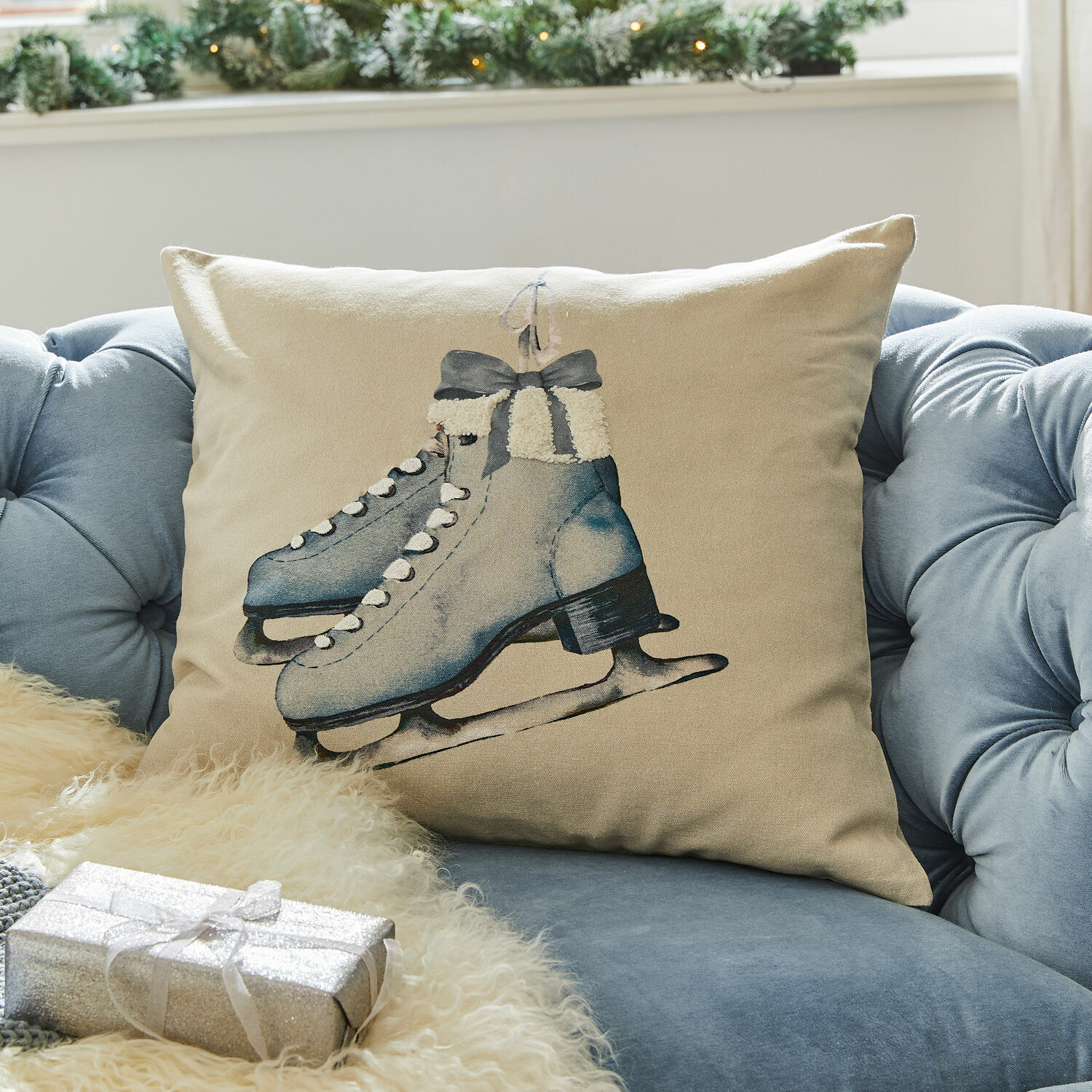 Housse de coussin Herveline Coussin beige avec motif de patins bleus sur canapé bleu, décoration hivernale et festive