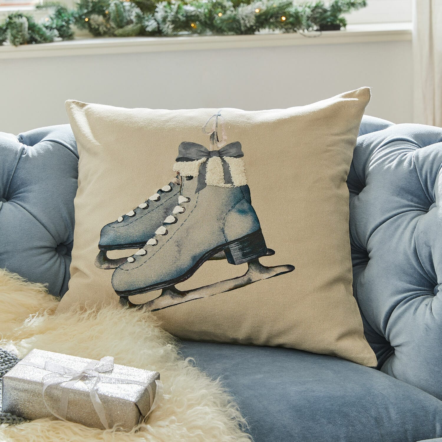 Housse de coussin Herveline Coussin beige avec motif de patins bleus sur canapé bleu, décoration hivernale et festive