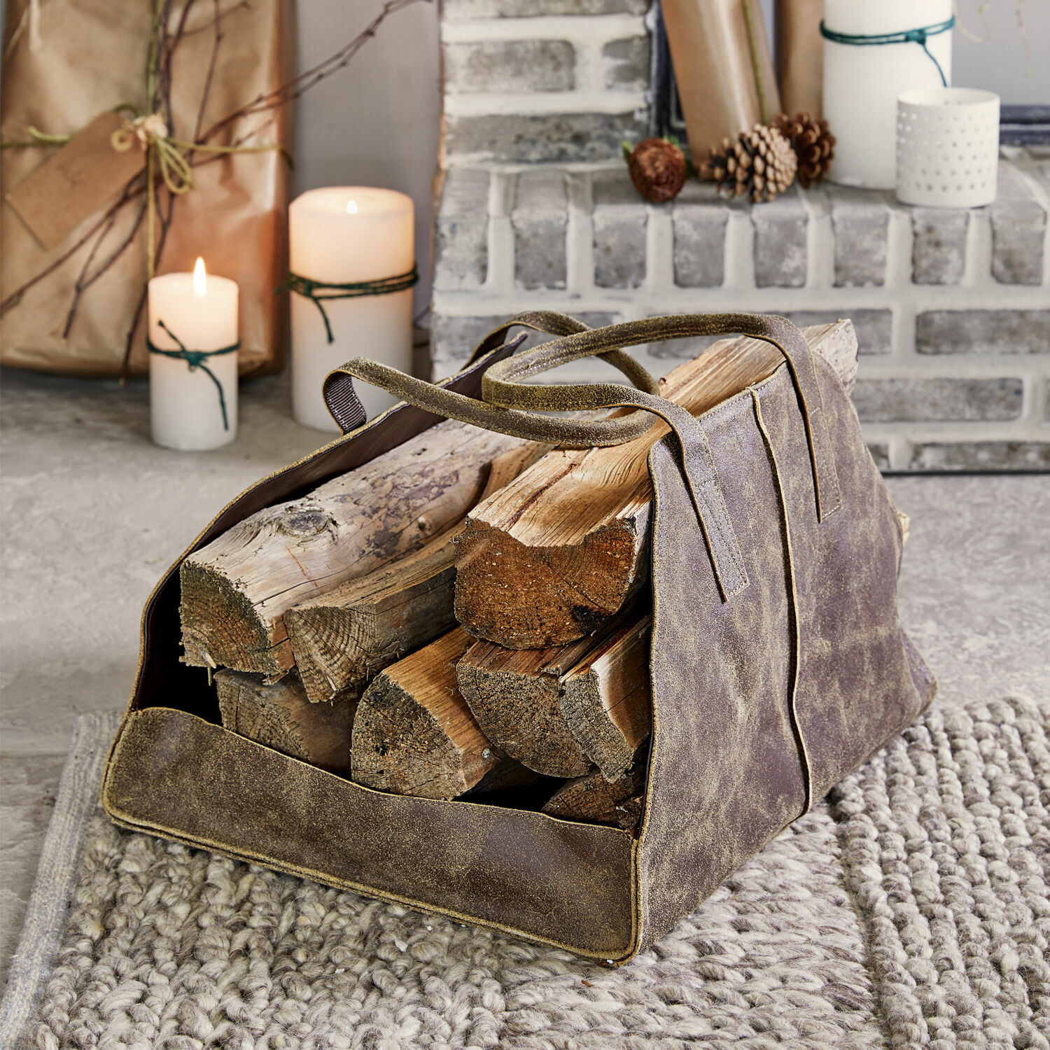 Sac porte-bûches Bassila Panier à bois en cuir marron avec poignées sur tapis gris près de la cheminée
