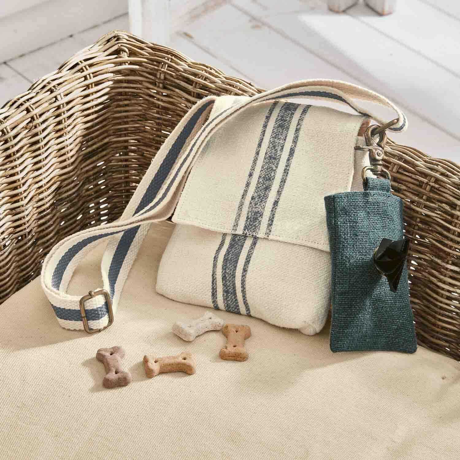 Sac en coton beige avec bandes bleues et étui pour friandises pour chien posé sur un canapé