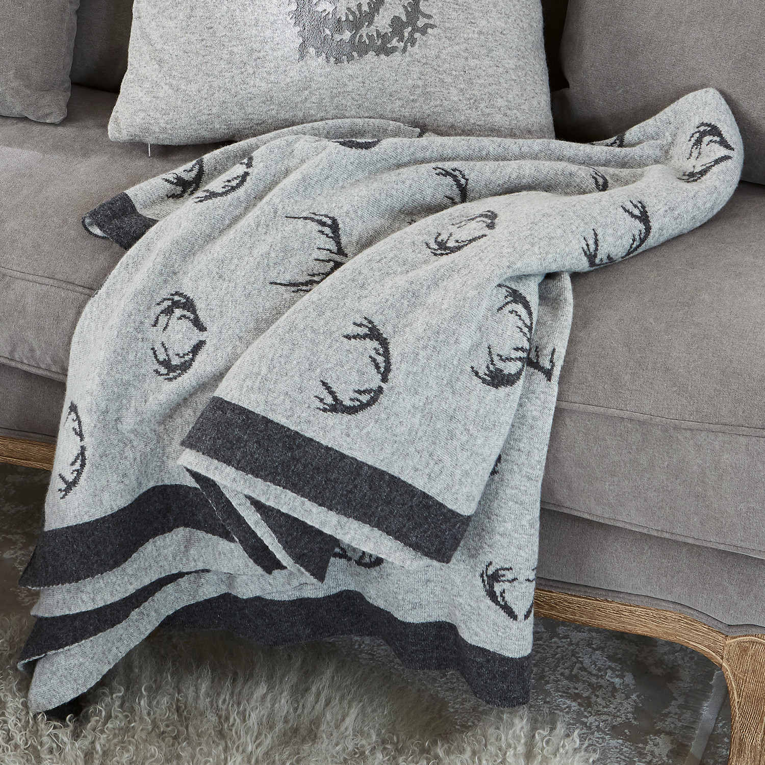 Plaid réversible Lodge Plaid en laine grise avec motif bois de cerf noir sur canapé gris, décoration intérieure cosy