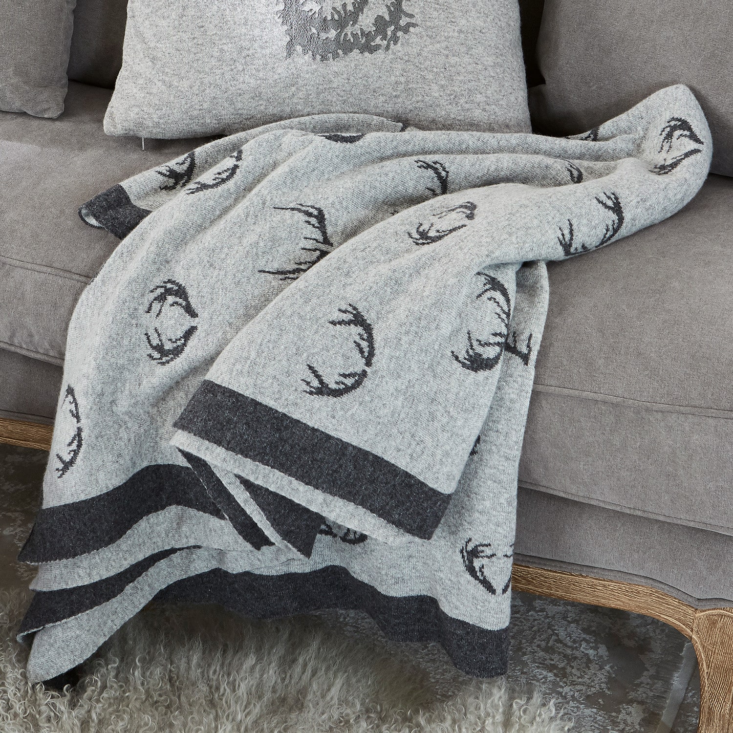 Plaid réversible Lodge Plaid en laine grise avec motif bois de cerf noir sur canapé gris, décoration intérieure cosy