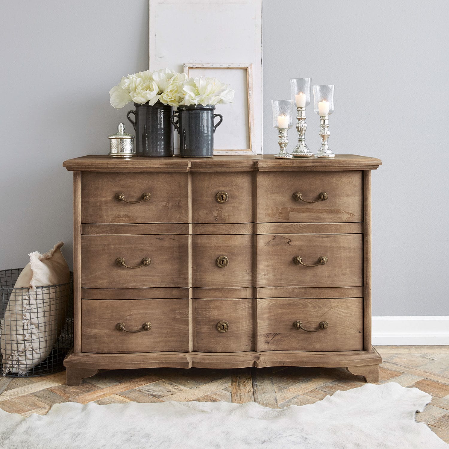Commode Aiguillon Commode en bois naturel avec six tiroirs et décorations sur le dessus dans un intérieur moderne