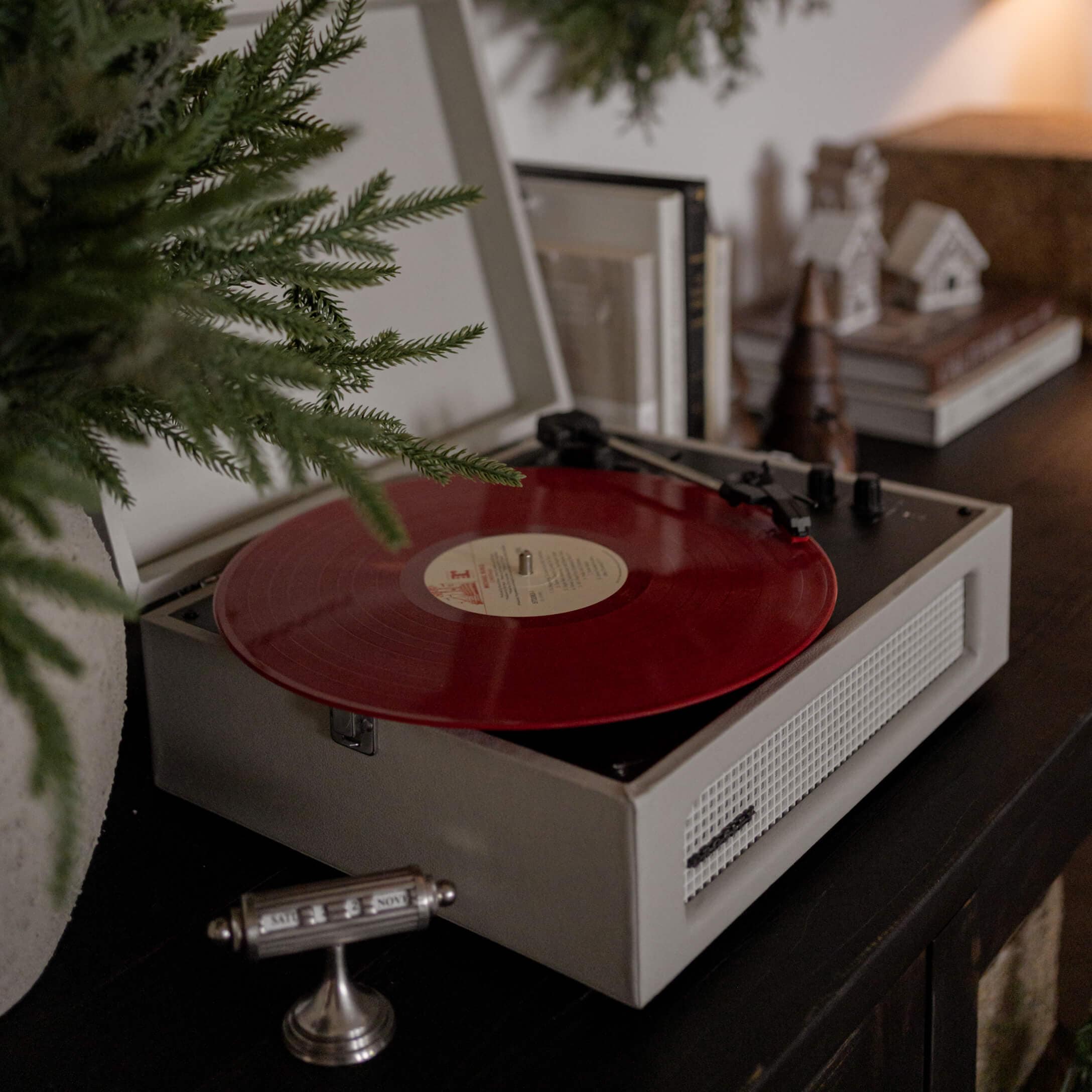 Platine vinyle rétro avec disque vinyle rouge sur meuble sombre dans un intérieur chaleureux