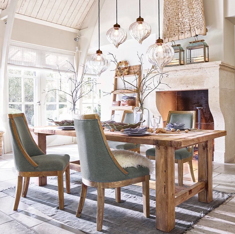 Salle à manger avec table en bois massif et chaises grises, suspensions en verre décoratives