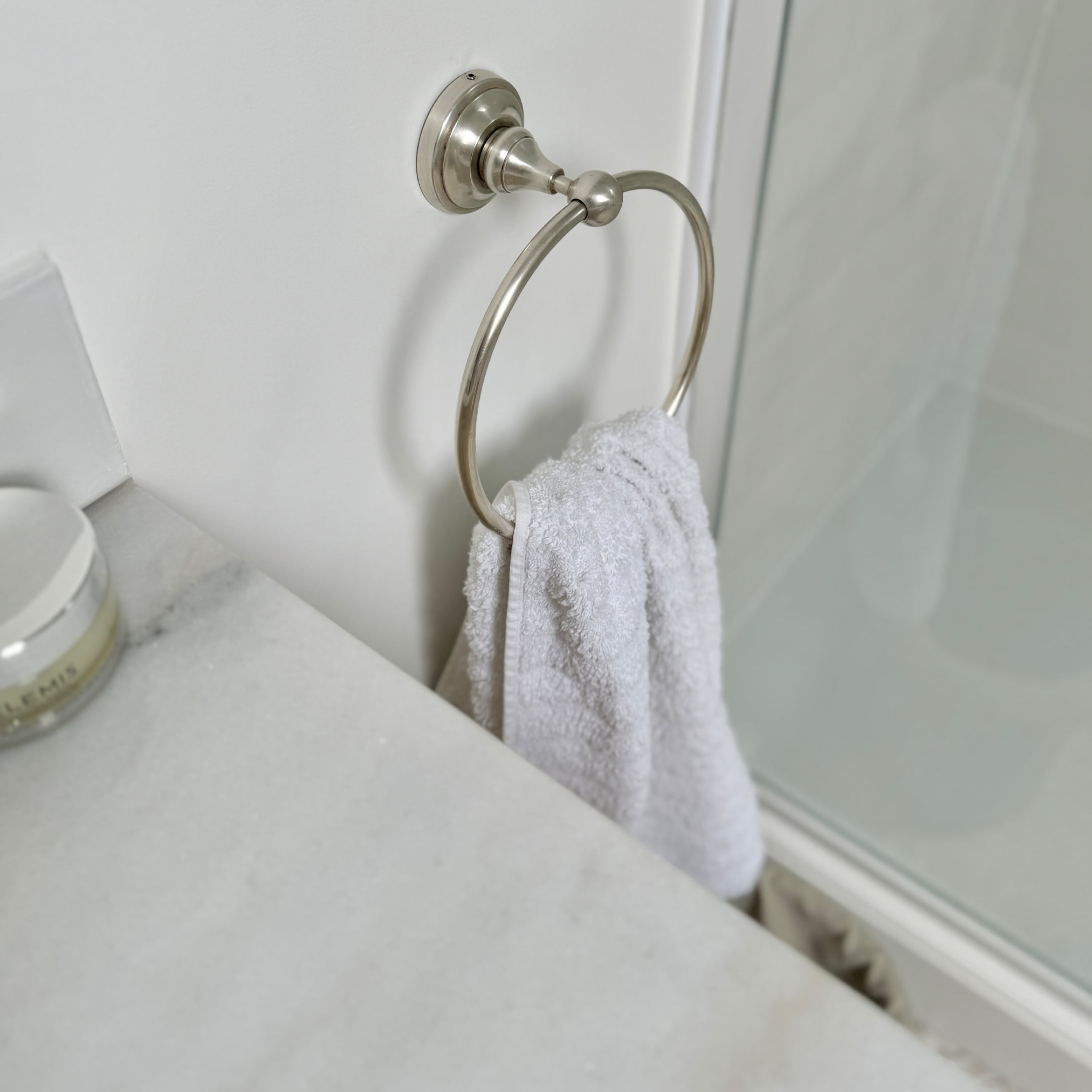 Anneau porte-serviette en métal avec serviette blanche et plan de travail en marbre dans la salle de bain